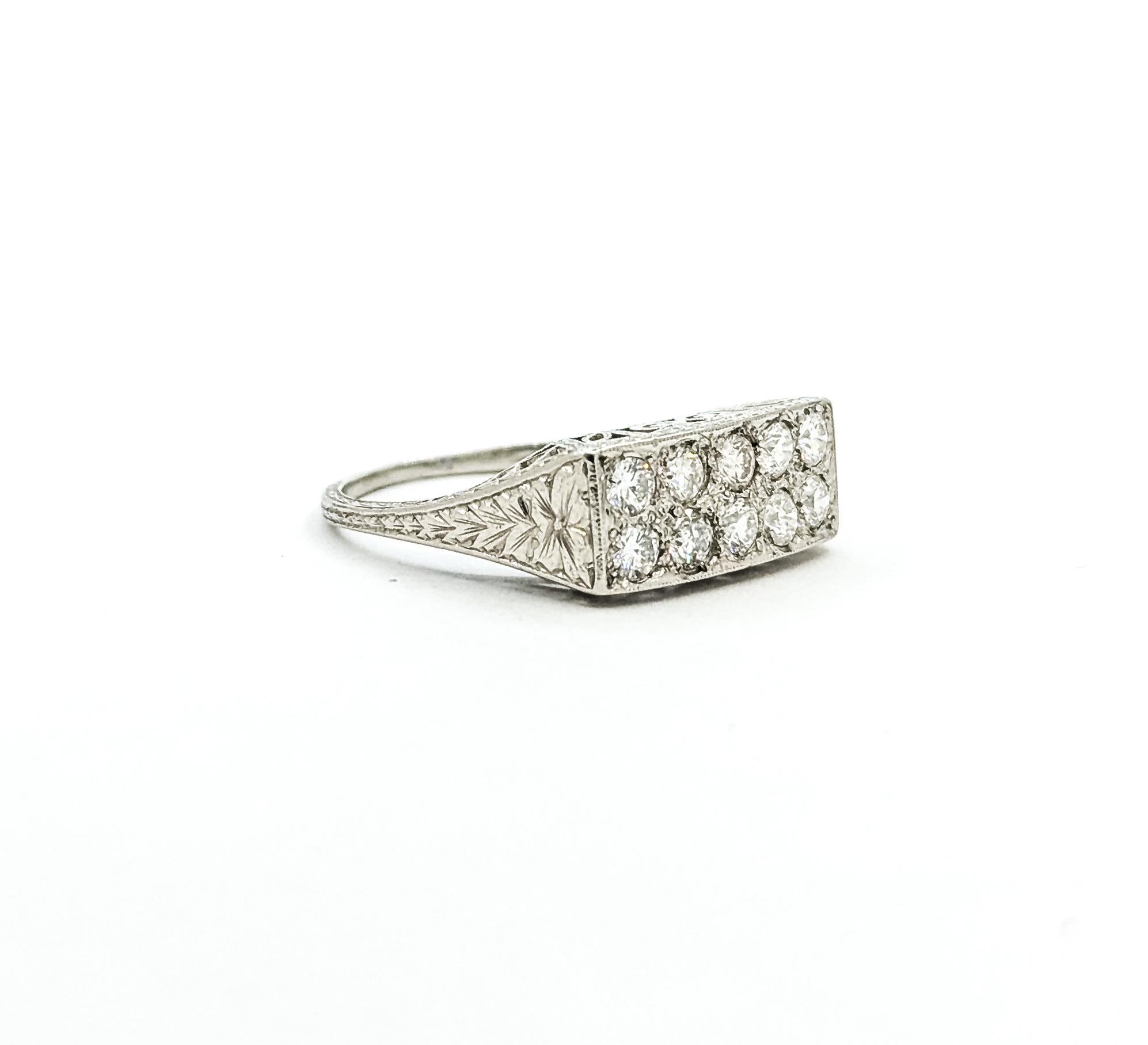 This ring is crafted in platinum and features bezel-set diamond, with a filigree design. A true example of the Mid Century era. The round diamonds total 0.65ctw, near colorless with I clarity.

The ring is currently a size 7.25. The ring measures