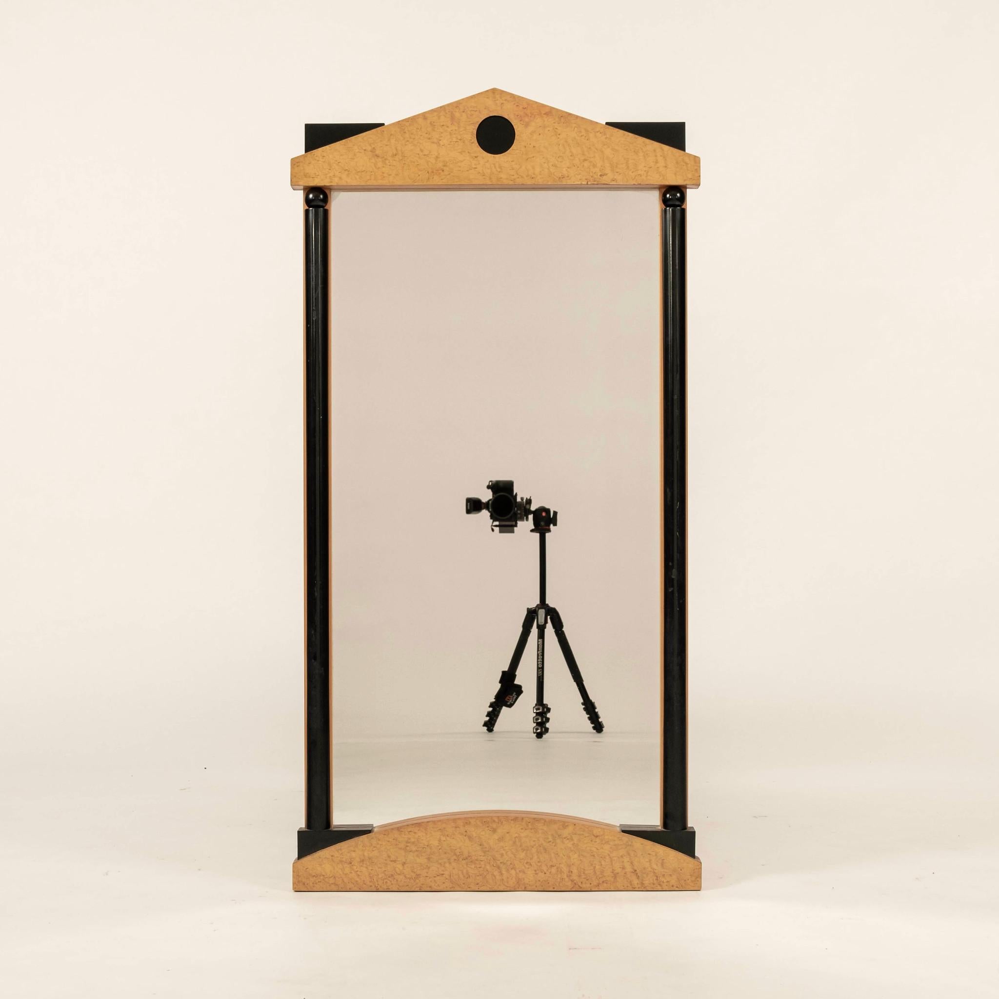 Mid-Century Biedermeier style mirror composed of a wood frame with burlwood veneer and ebonized side columns.