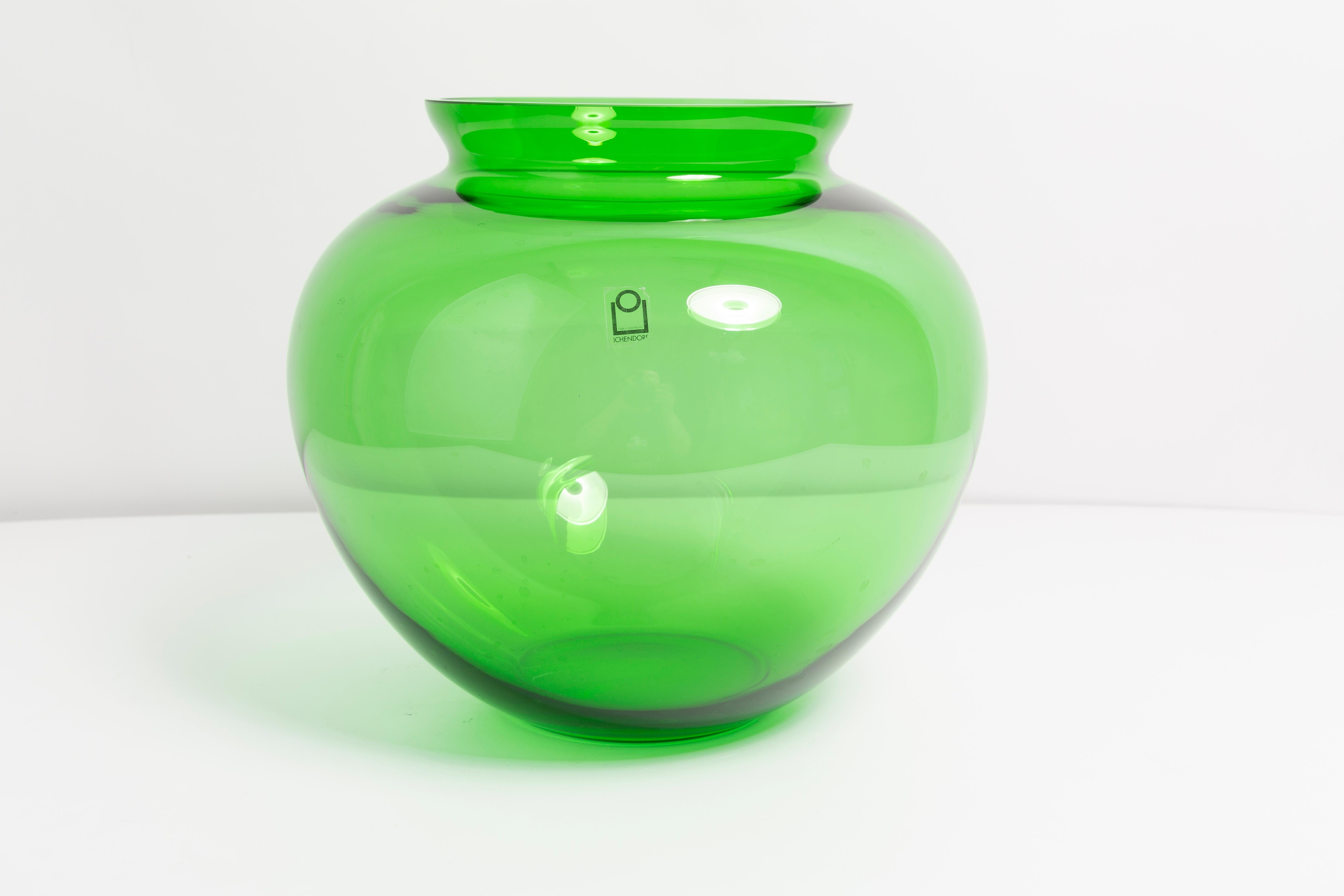 Vase vert en très bon état. Produit dans les années 1960.
Verre en parfait état. Le vase semble avoir été sorti de sa boîte.

Pas d'accrocs, de défauts, etc. La surface extérieure en relief, l'intérieur lisse. Vase en verre épais, massif.

 Une