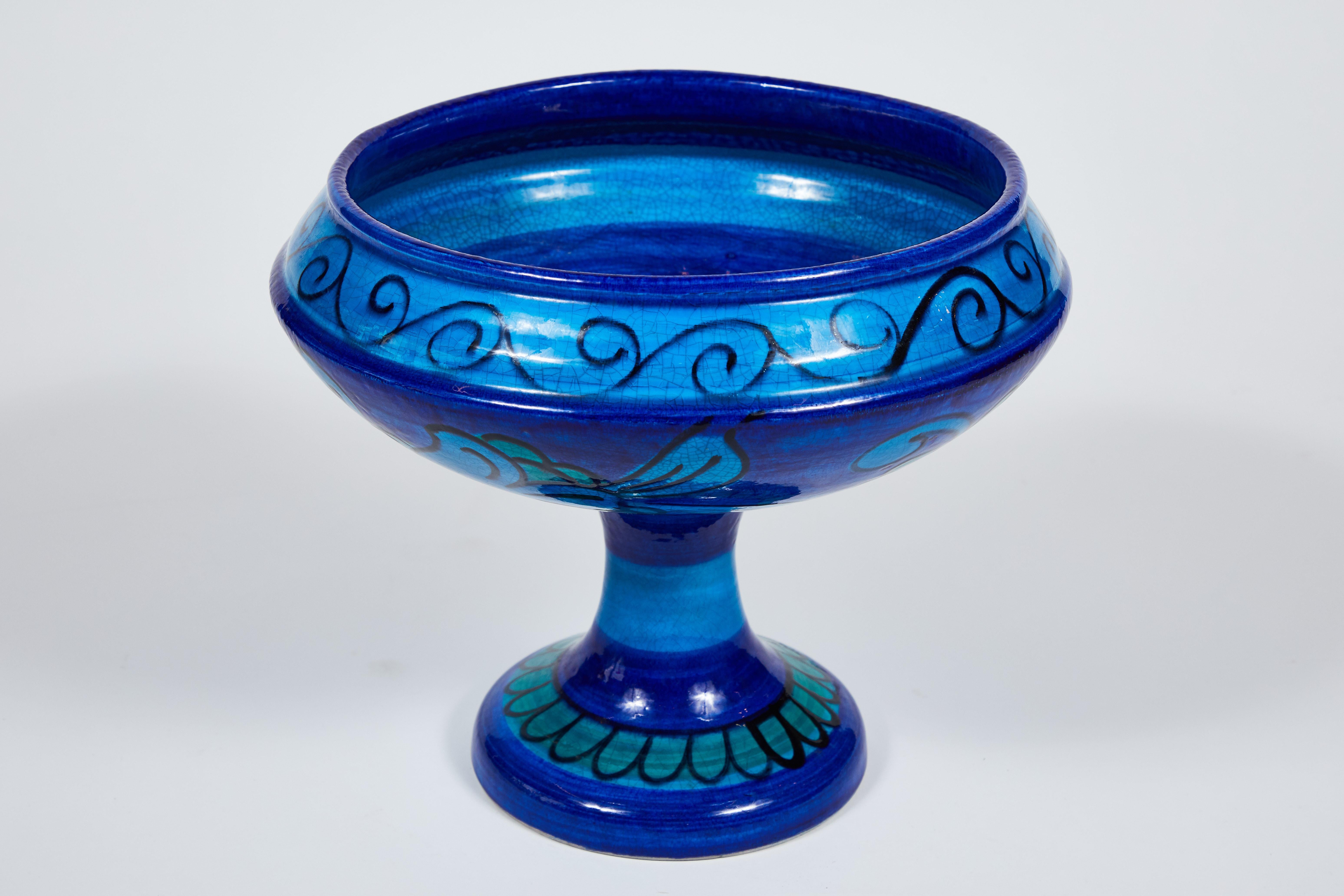 This is a tall footed bowl or presentation bowl in the famous Bitossi blue glaze. This example features a striped pedestal and hand painted floral decoration, an impressive standing vase with the Classic glaze colors of the 1960s: Green, turquoise,