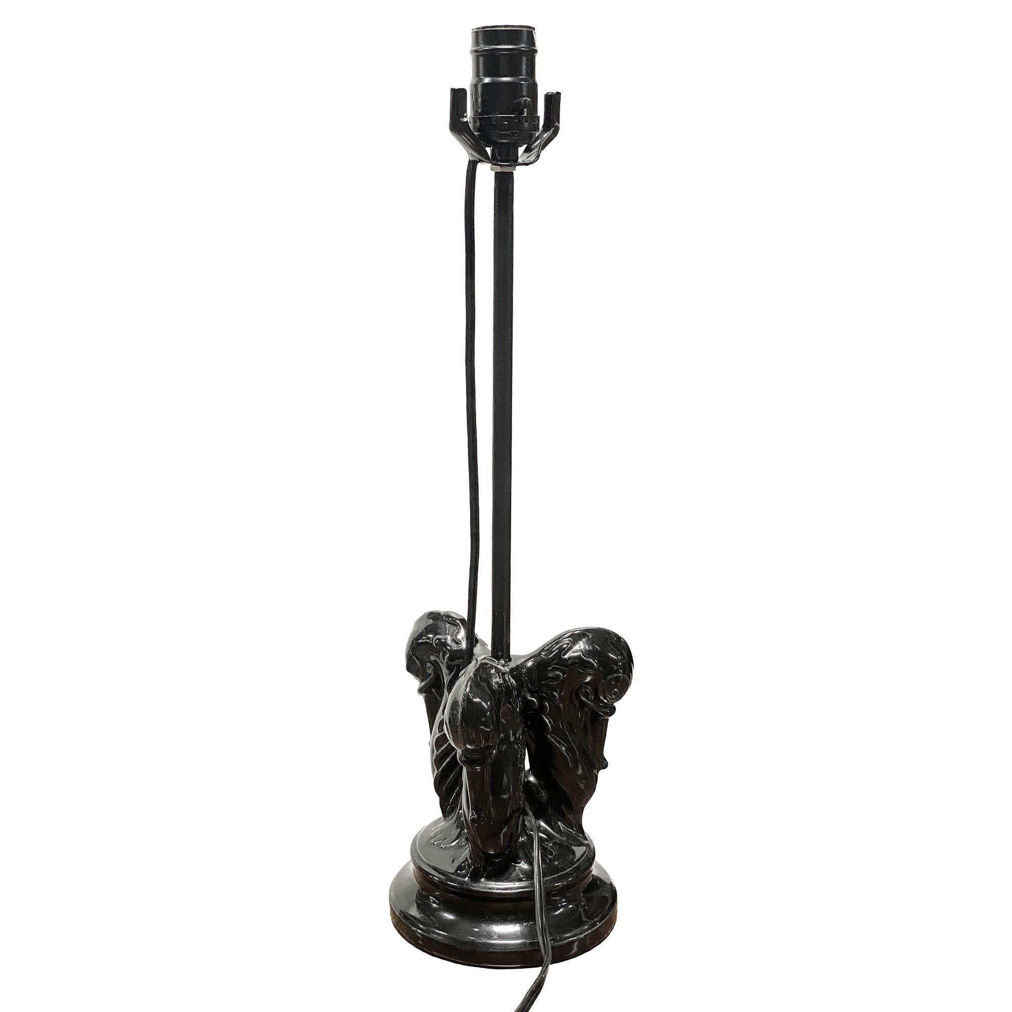 Lampe de table en céramique émaillée noire du milieu du siècle, présentant d'élégantes figures à deux têtes de cygne, sculptées avec des courbes gracieuses et une finition brillante. Cette pièce remarquable allie une forme sculpturale à un design