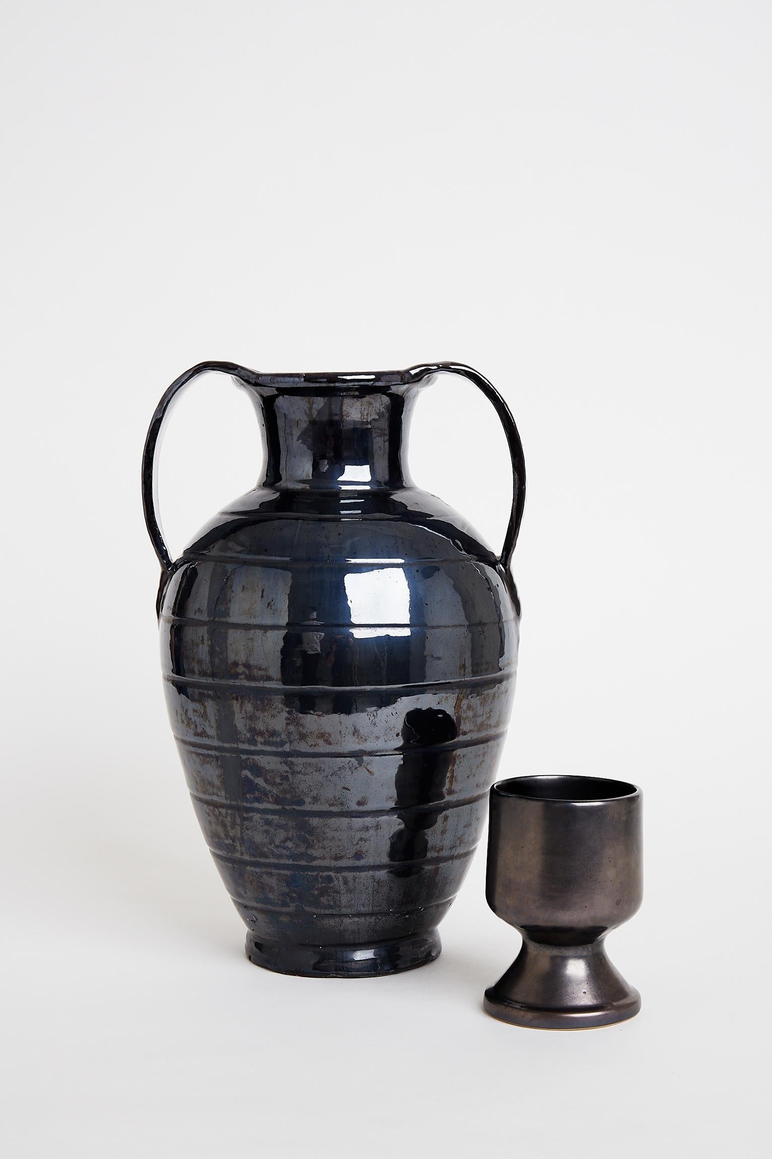 A large black ceramic and metallic glaze urn.
France, 1950s.