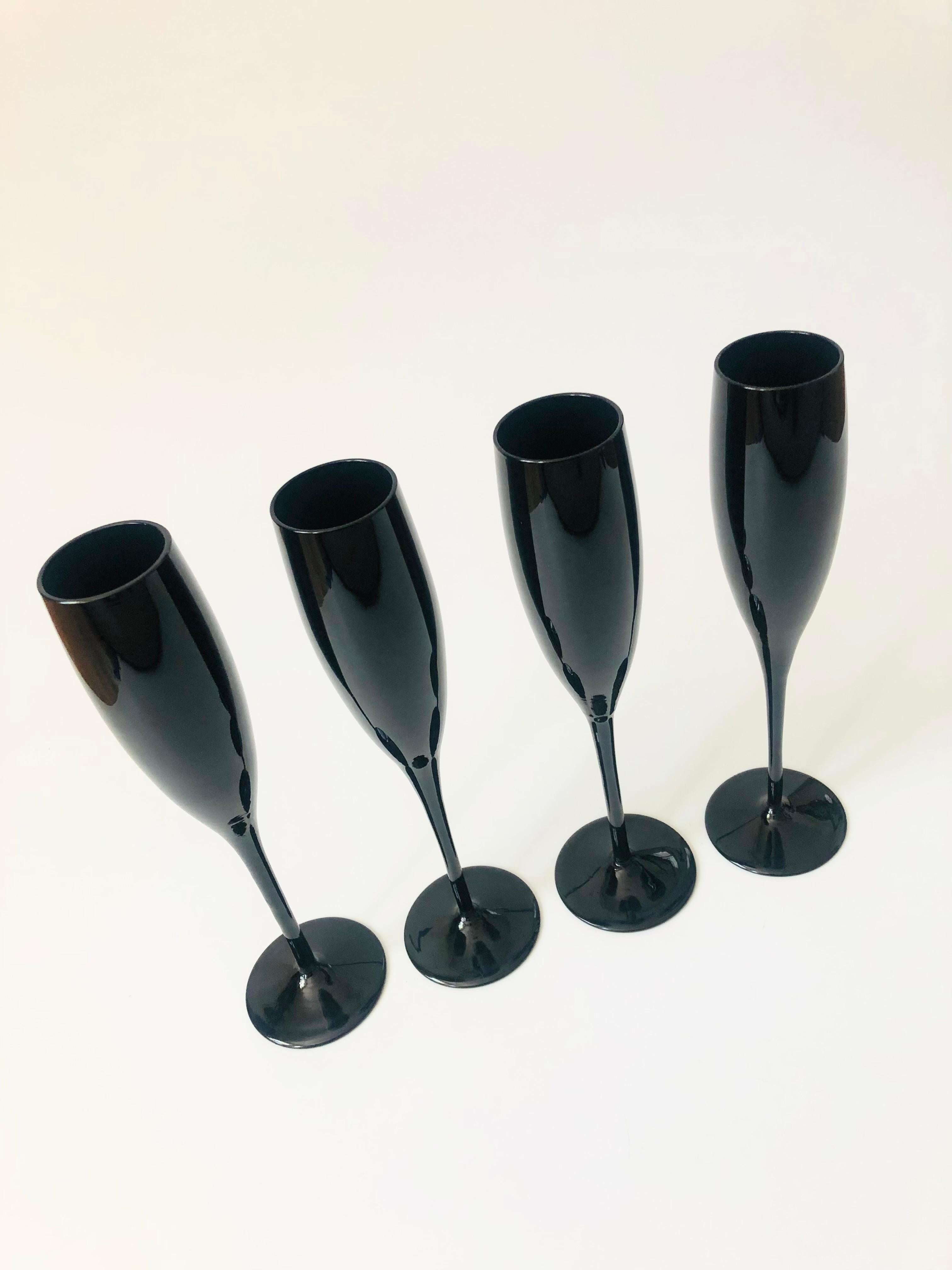 A set of 4 beautiful mid century black champagne flutes. Each in an elegant shape with a tapered stem.
  