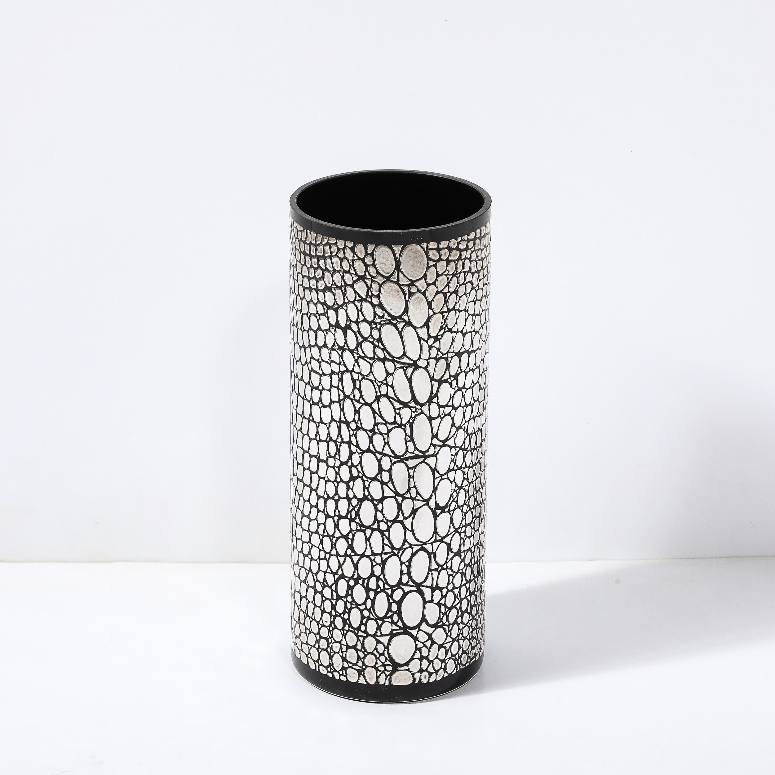 Questo vaso in vetro nero del Mid-Century Modernist, realizzato in Italia intorno al 1980, è un pezzo di grande impatto visivo che mette in mostra l'innovazione e la maestria del suo tempo. Il vaso è impreziosito da un intricato rivestimento in