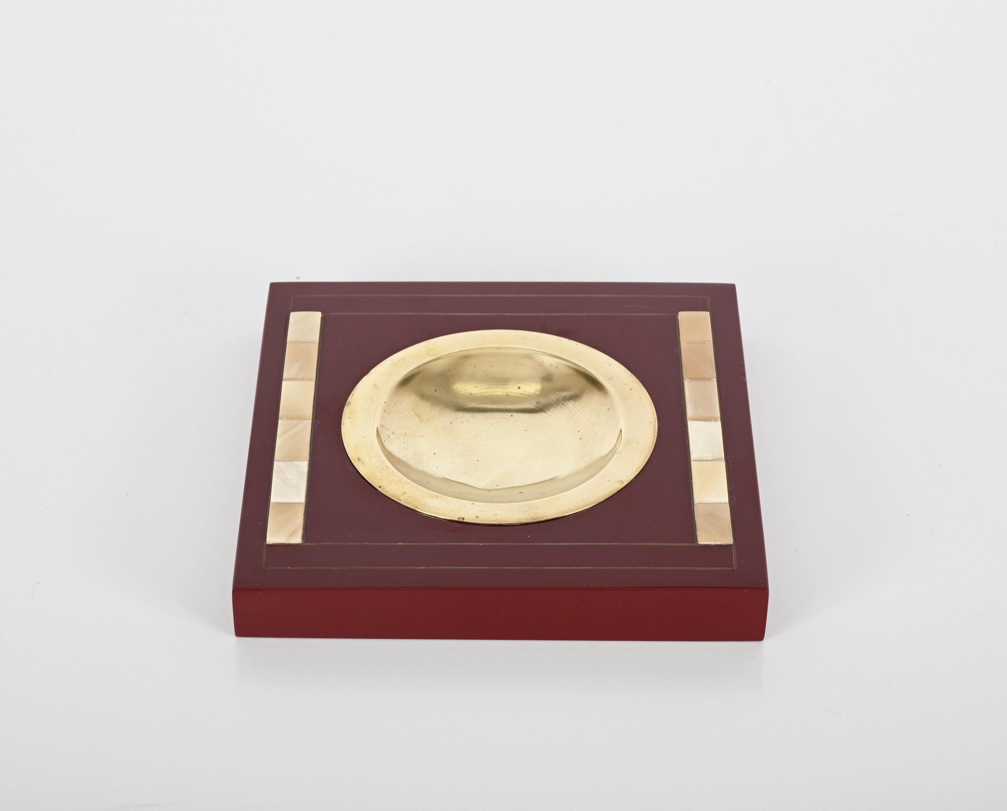 Delightful square pocket tray or ashtray made in burgundy lacquered wood, shell and brass. This incredibly elegant object is attributed to Tommaso Barbi and was made in Italy during the 1970s clearly in the style of a Dior production.

Splendid