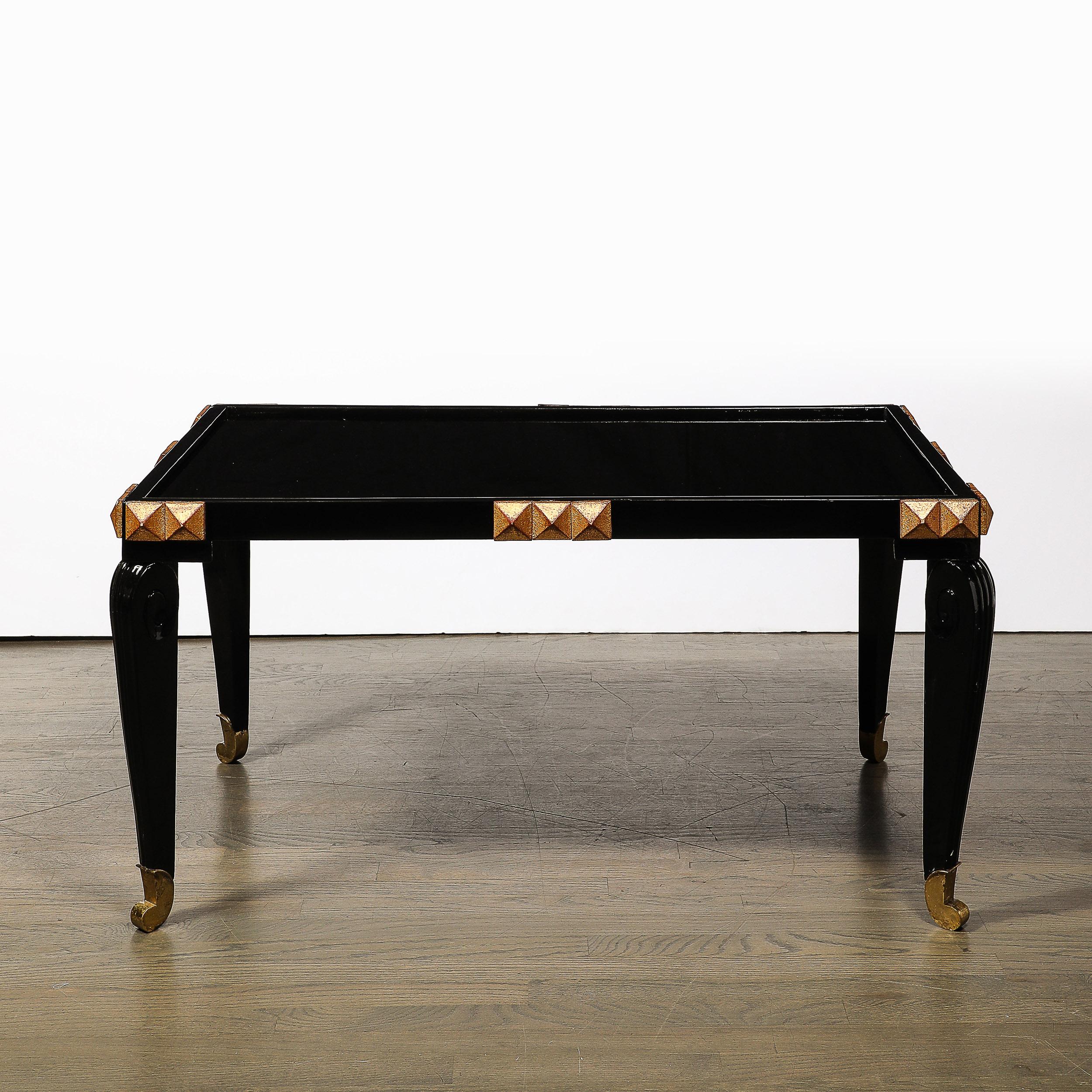 Cette table à cocktail moderniste du milieu du siècle, en laque noire, bois doré et laiton, avec plateau en vitrolite, est originaire de France, vers 1945. Cette pièce présente une composition et des matériaux excellents, avec une surface laquée