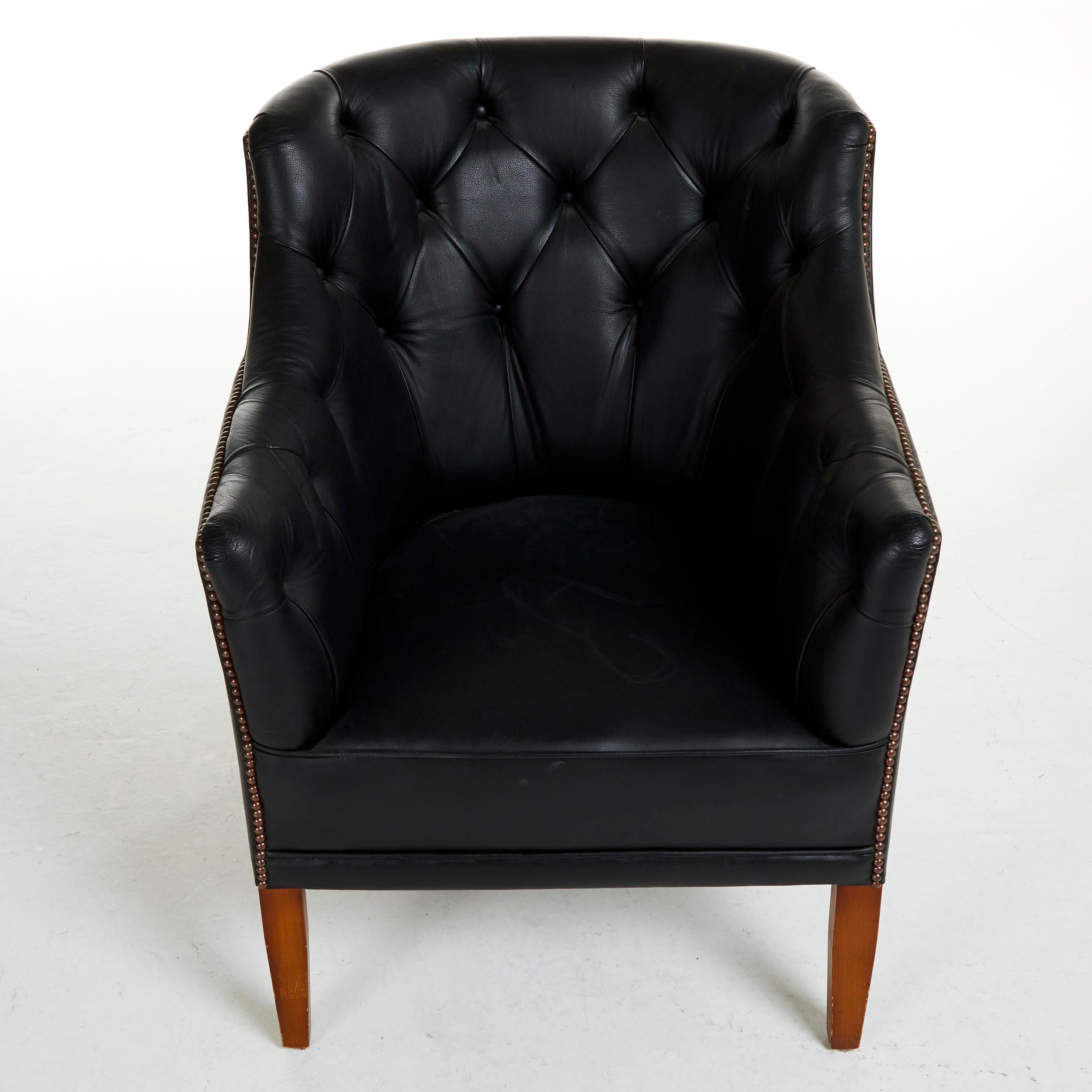 Armchair, around mid-1900s, mahogany legs, deep-stitched upholstery in black leather, pearl-spiked décor.


