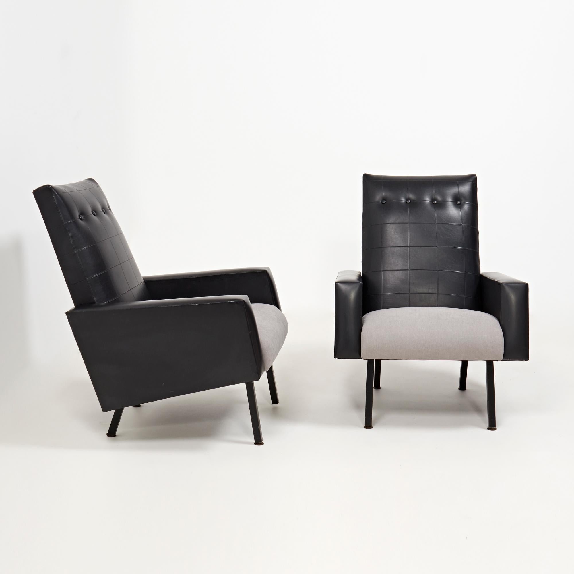 Designed in the style of Pierre Guauriche, this set of armchairs have a Classic Mid Century aesthetic.

Featuring a striking silhouette, the chairs sit on black metal legs and are upholstered in black vinyl leather with a contrasting grey fabric