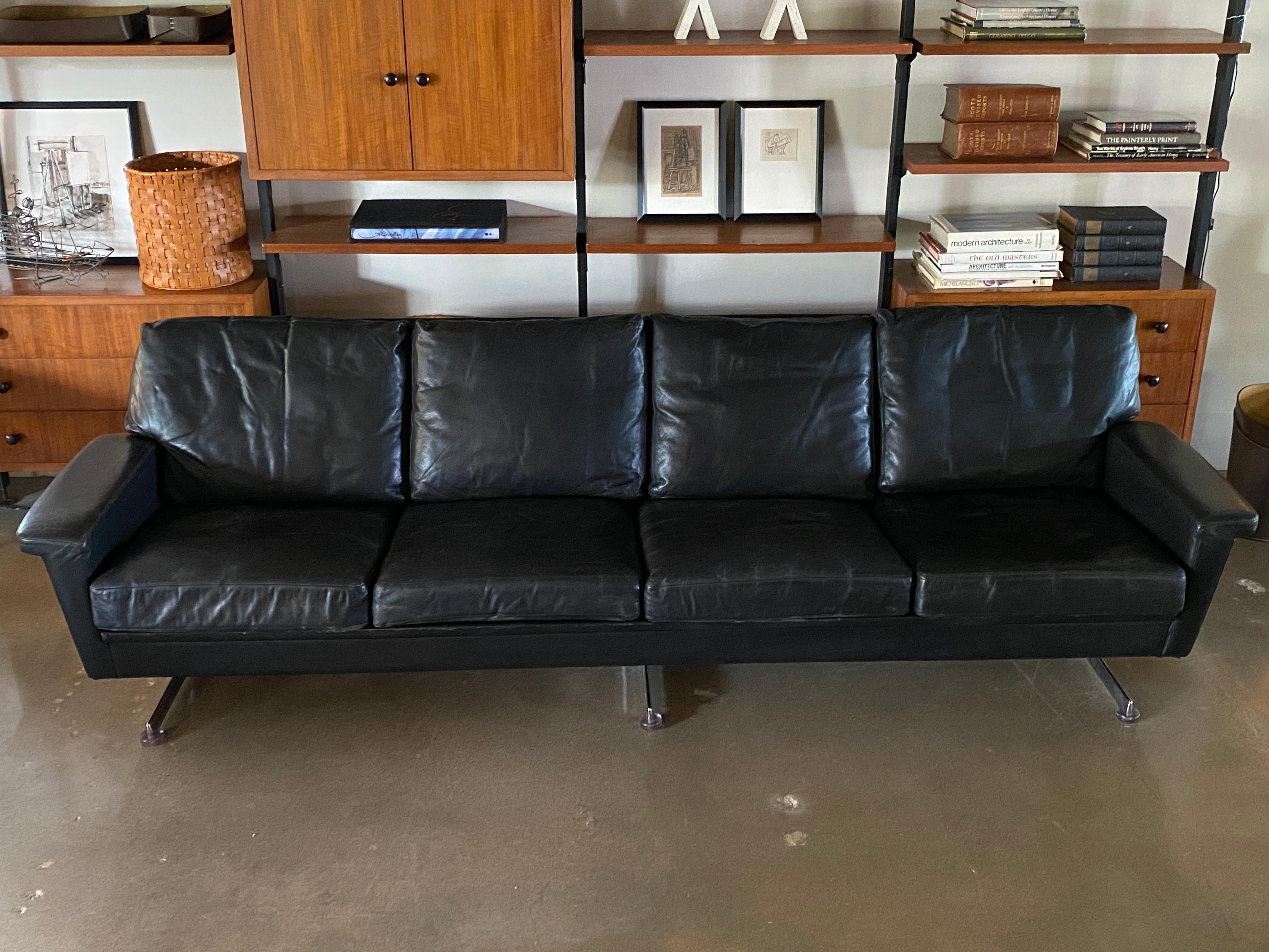 Well styled four cushion sofa with chrome legged base, typical of Italian furniture from the 1950s and 1960s. Chrome legs have acrylic feet. Black leather is in beautiful condition with just the right amount of patina. A very comfortable sofa with