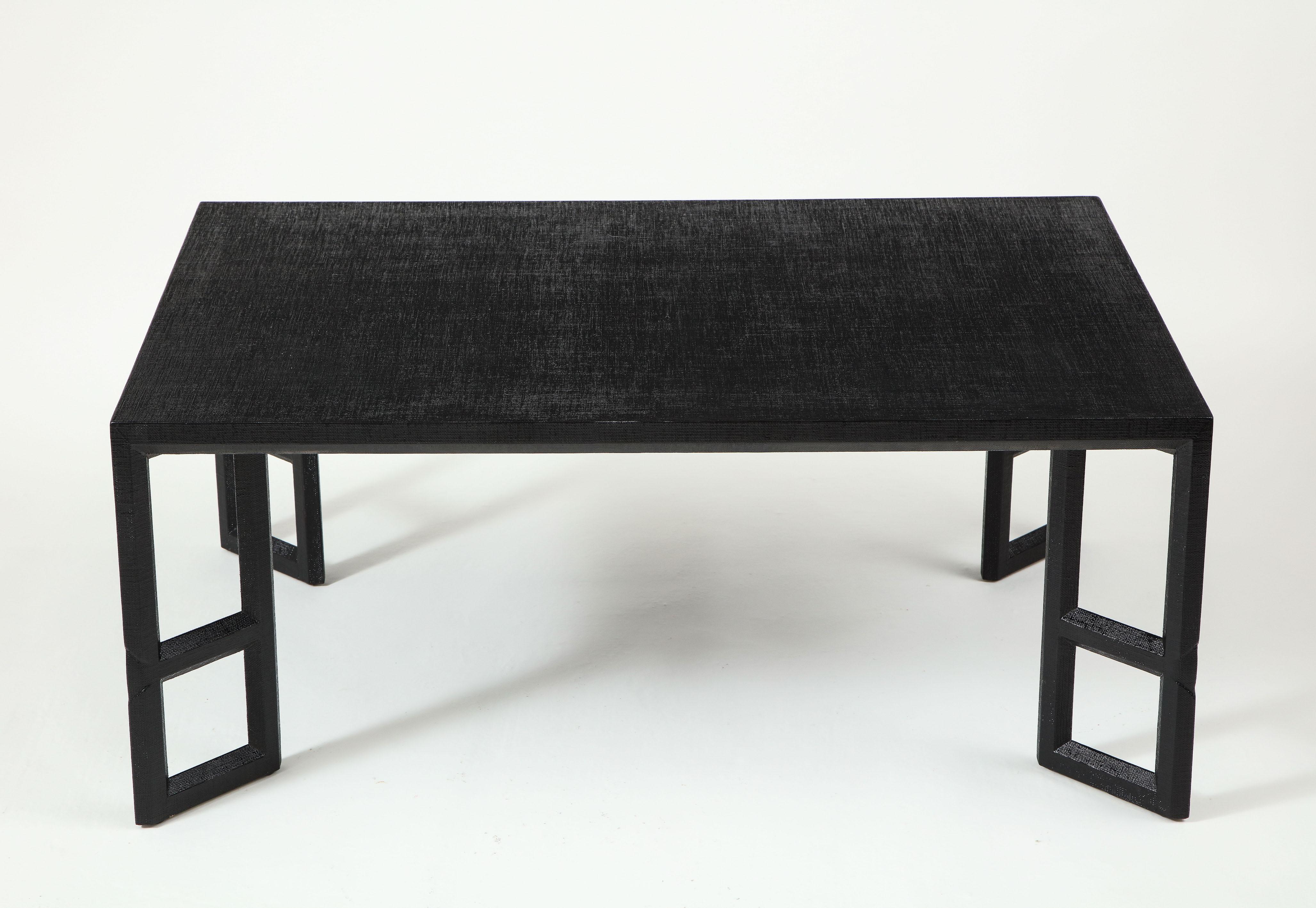The rectangular top raised on angled open supports, all wrapped in black-painted linen.
