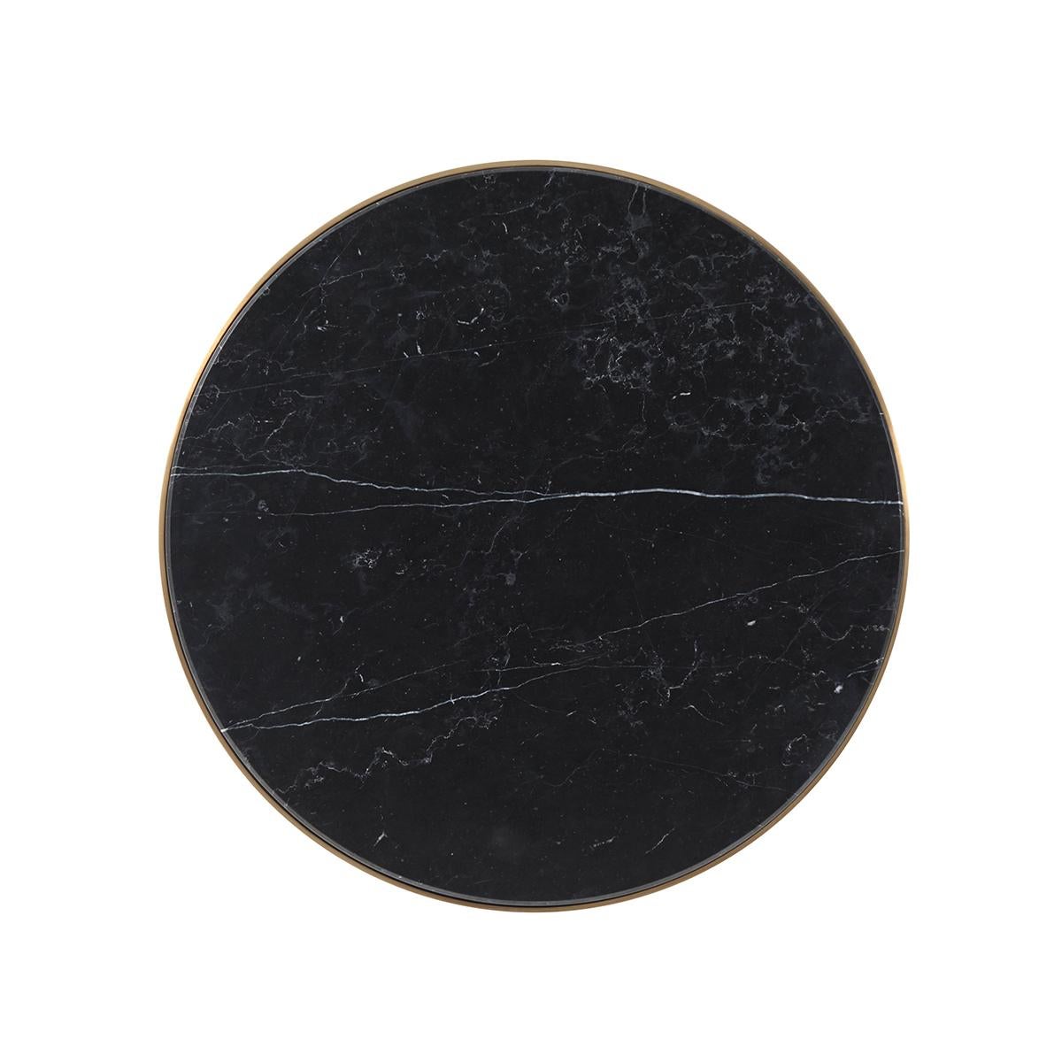 With a round black marble top on a brushed brass finish metal base with tapering legs.

Dimensions: 19.75