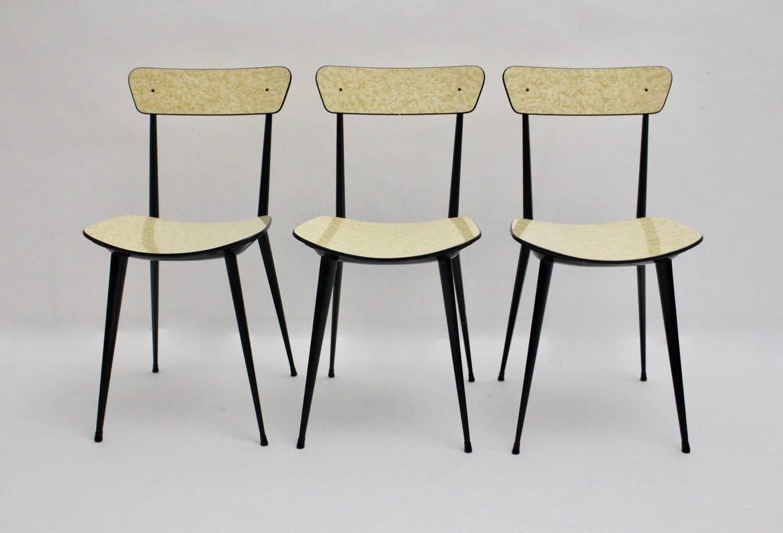 Mid Century Modern three ( 3 ) dining room chairs very similar to the design by Carlo di Carli in butter cream and black color.
The base was made of black lacquered metal, while the seat and the back are from formica. Underneath the seat it shows