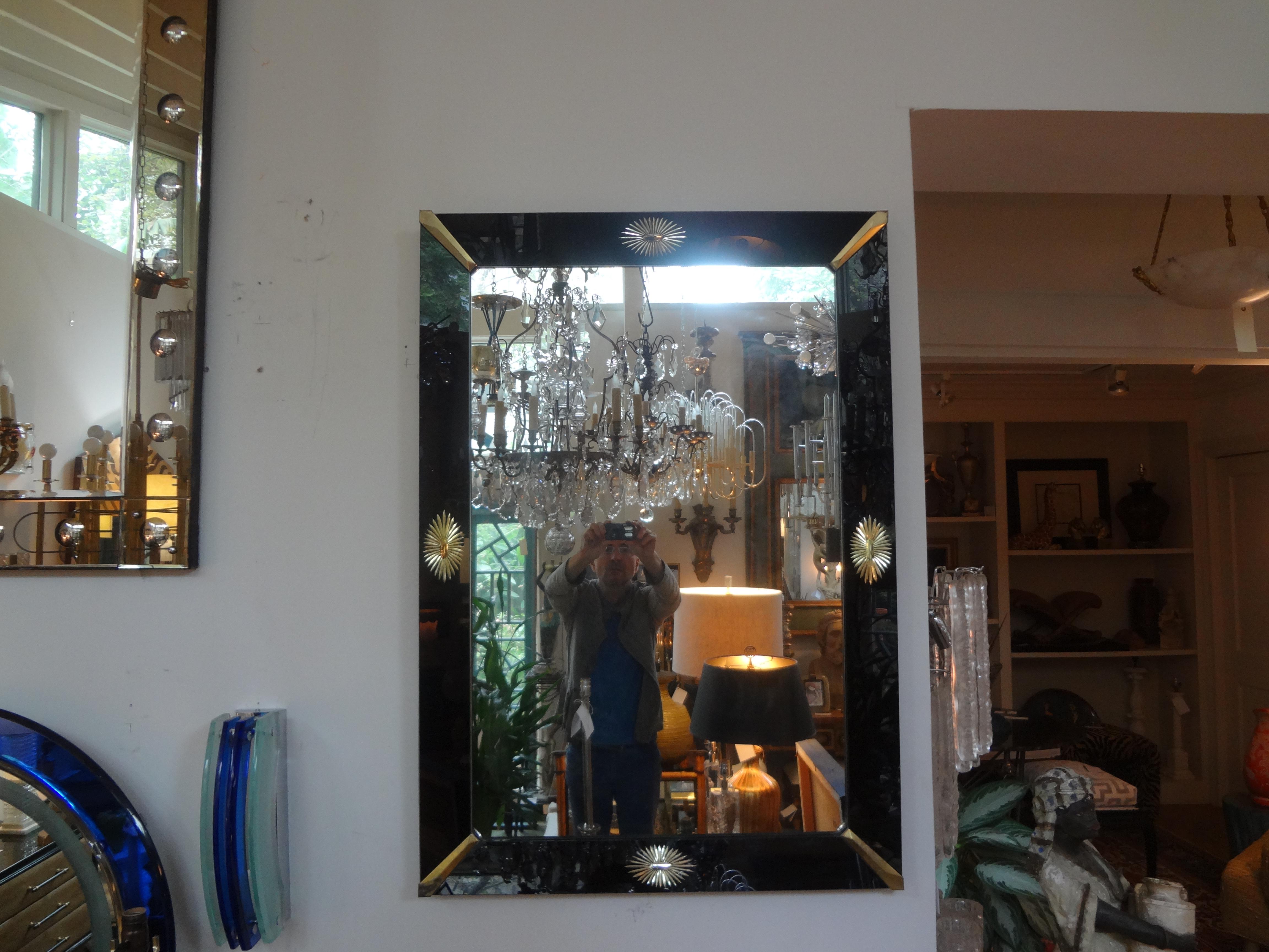 Stunning midcentury neoclassical style rectangular Venetian mirror with a black mirrored perimeter, brass corners and a central gilt star on each side.
This beautiful mirror can be displayed in either direction. We have a slightly smaller