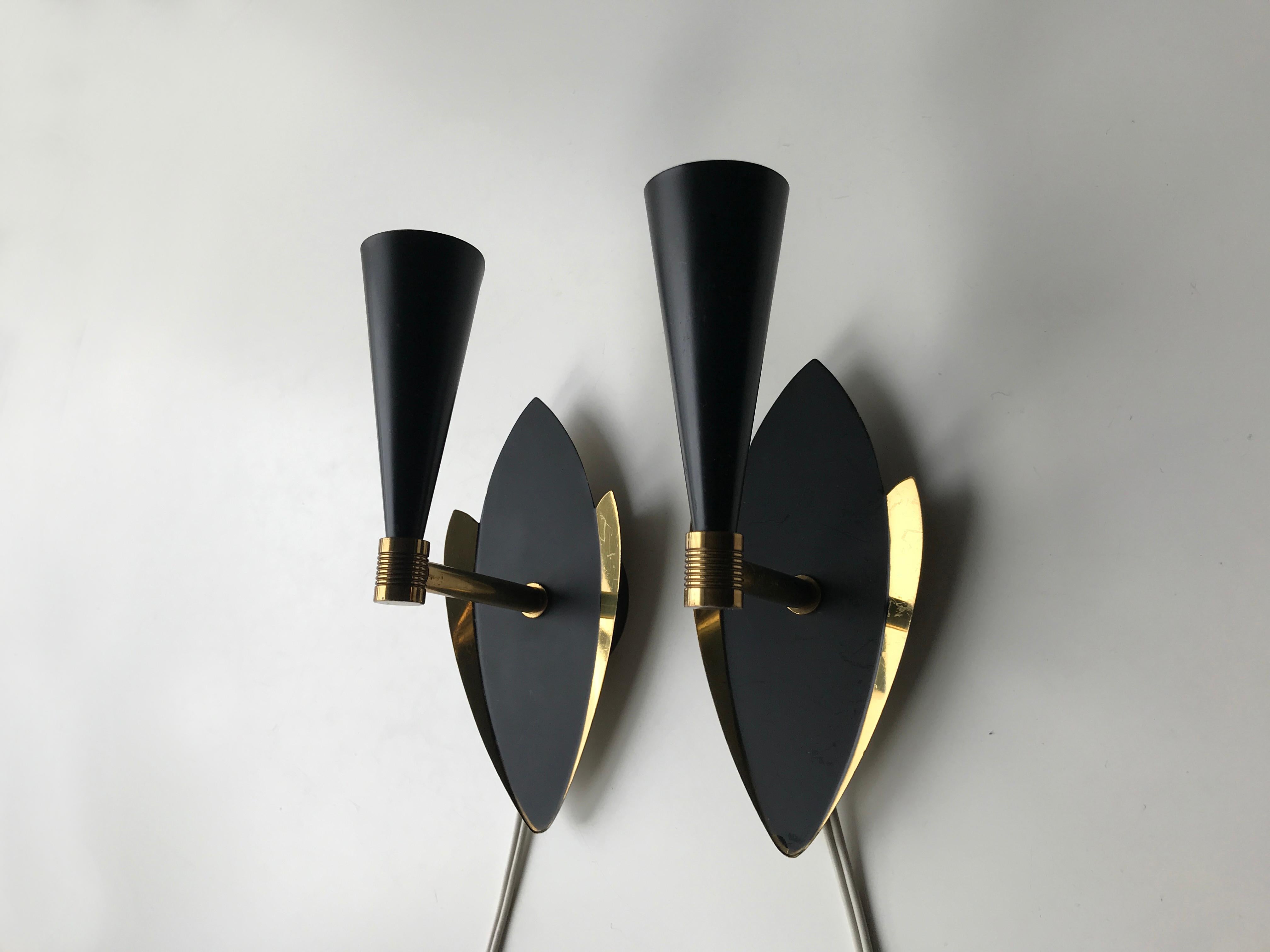 Mid-Century Diablo style Black satin and polished brass pair of wall sconces. Circular wall base with front plate of black matte satin colored surface and wings of polished brass. No label or marks to identify but presumably made by Danish