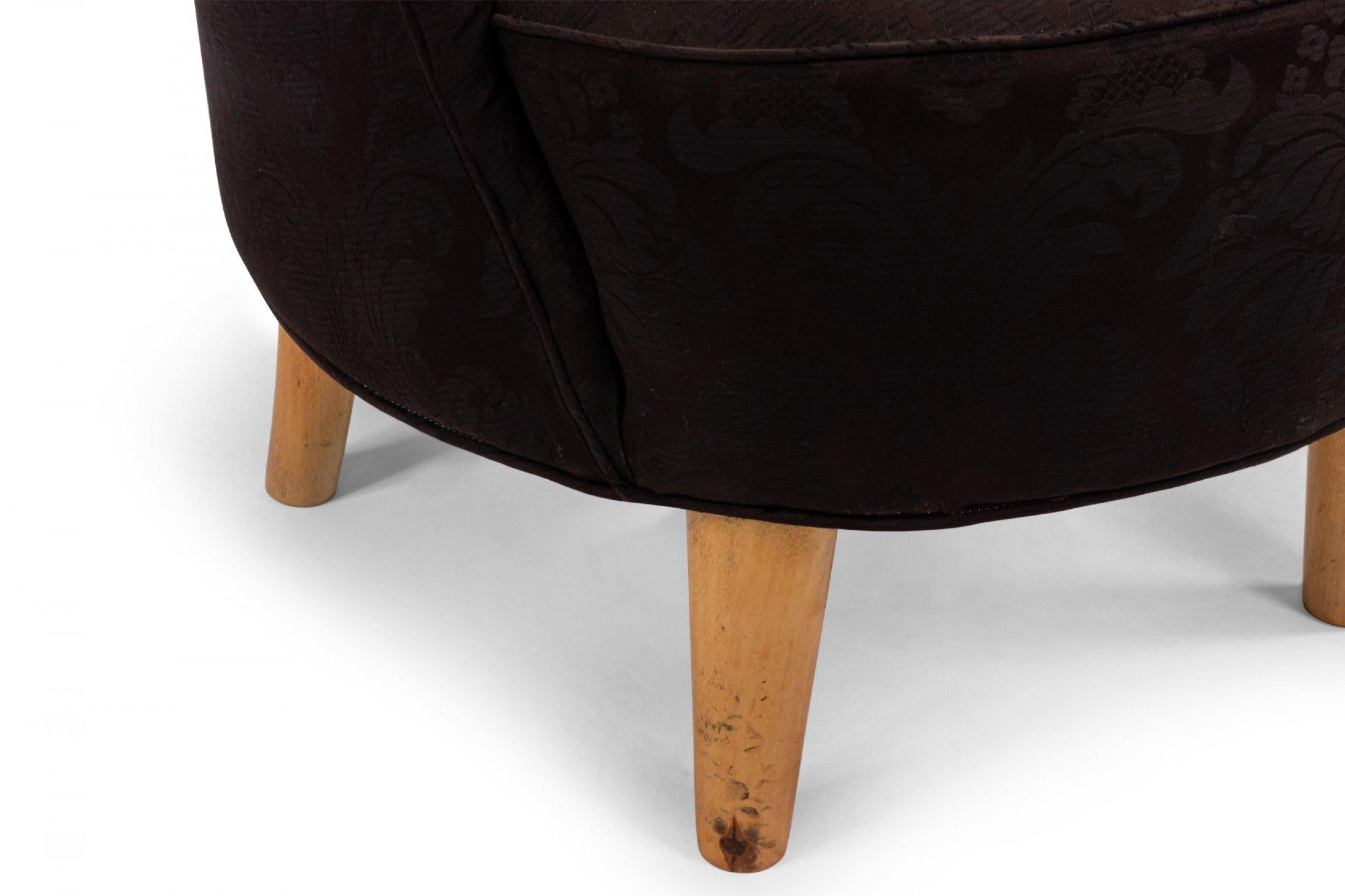 American Art Moderne/contemporary tub chair with black upholstered low round back supported on blond wood tapered round legs.
  