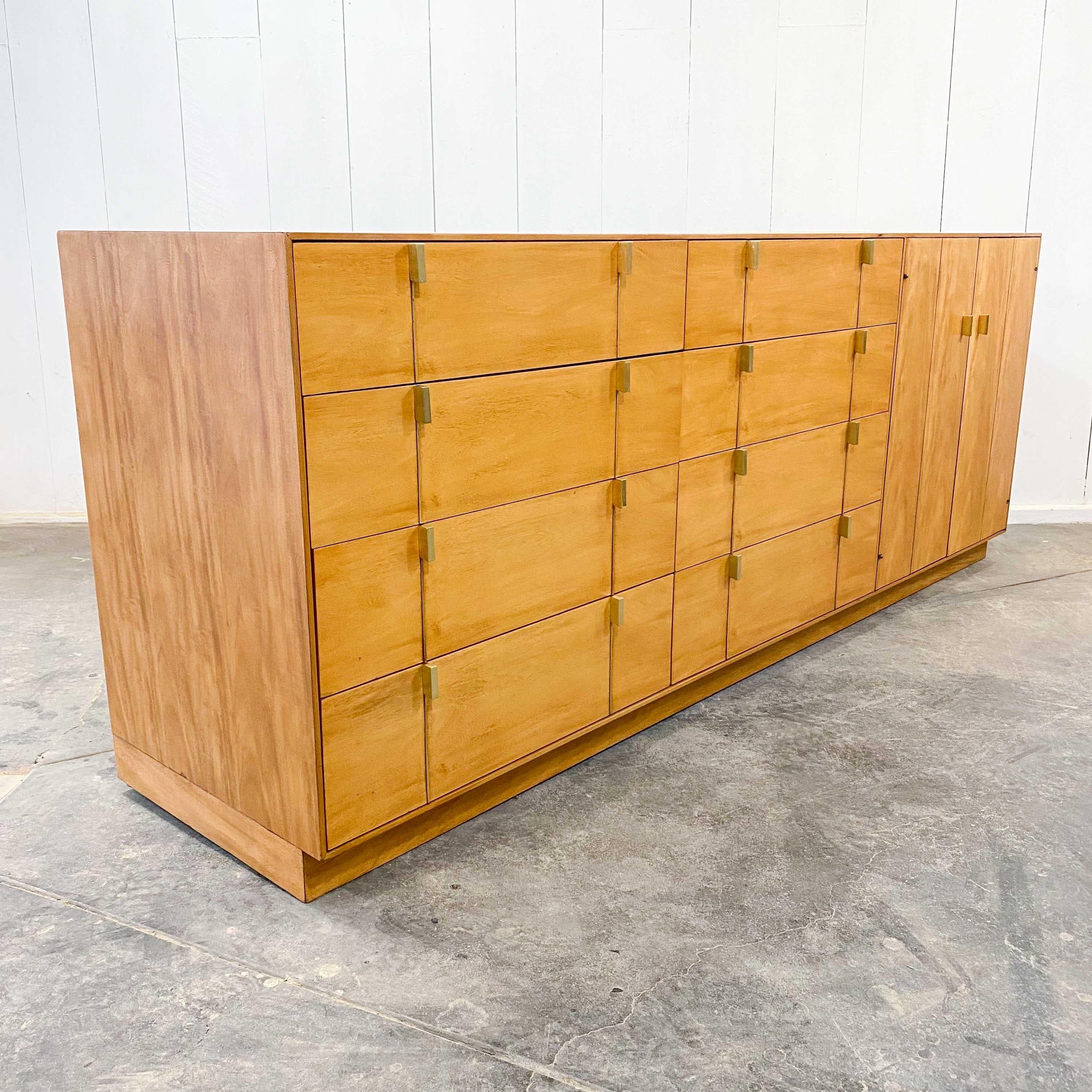 An 8 drawer dresser / sideboard with built in side cabinet to create a versatile storage unit by the Hickory Manufacturing Company of Hickory, North Carolina in 1983. 
A bleached mahogany veneered cabinet with elegant brass pulls restored to its