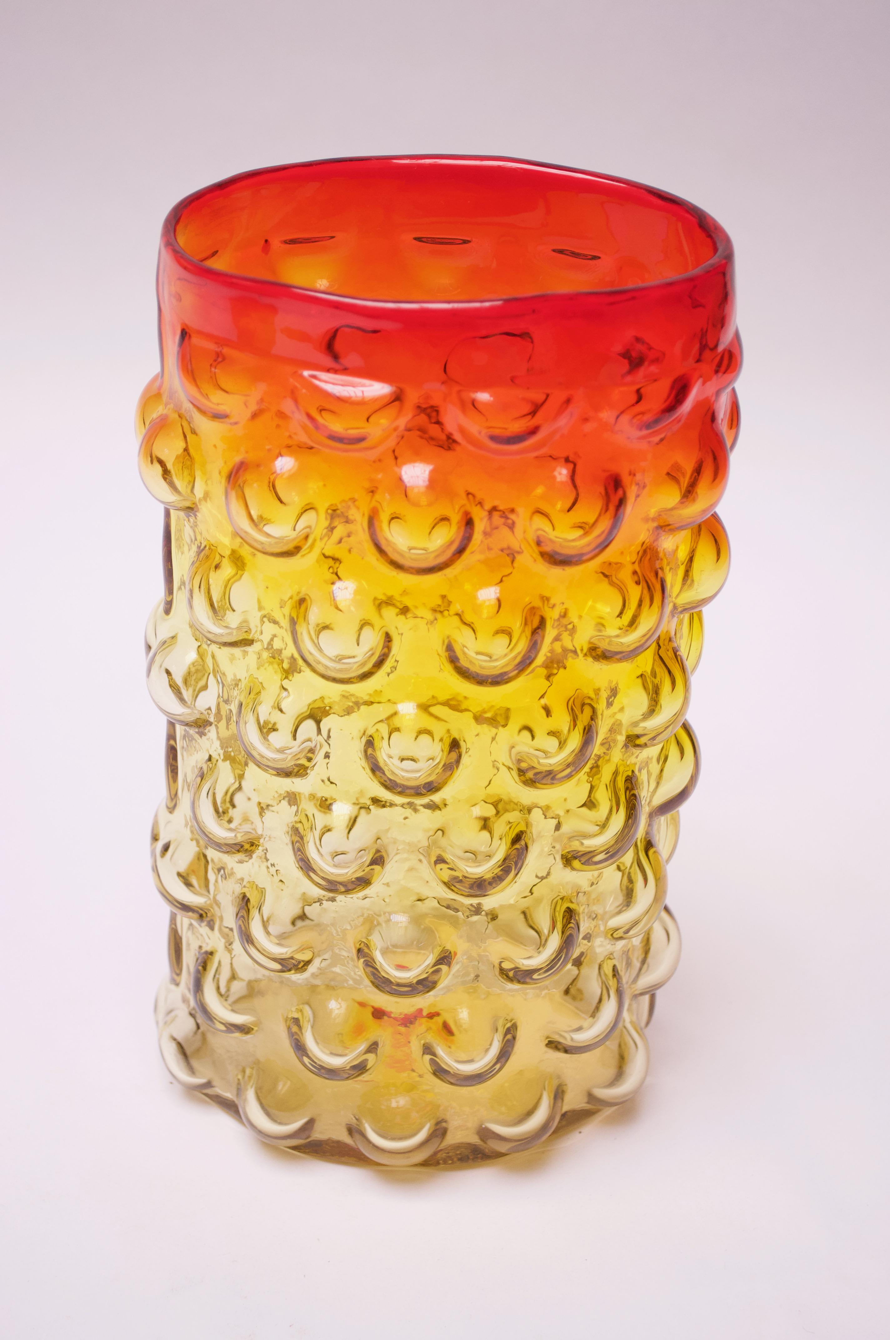 Blown glass vase designed in 1961 by Wayne Husted for Blenko (model number 6041). Attractive 'bubble' pattern throughout and brilliant amberina / tangerine palette with red and yellow meeting to produce an orange banding toward the top. 
Features