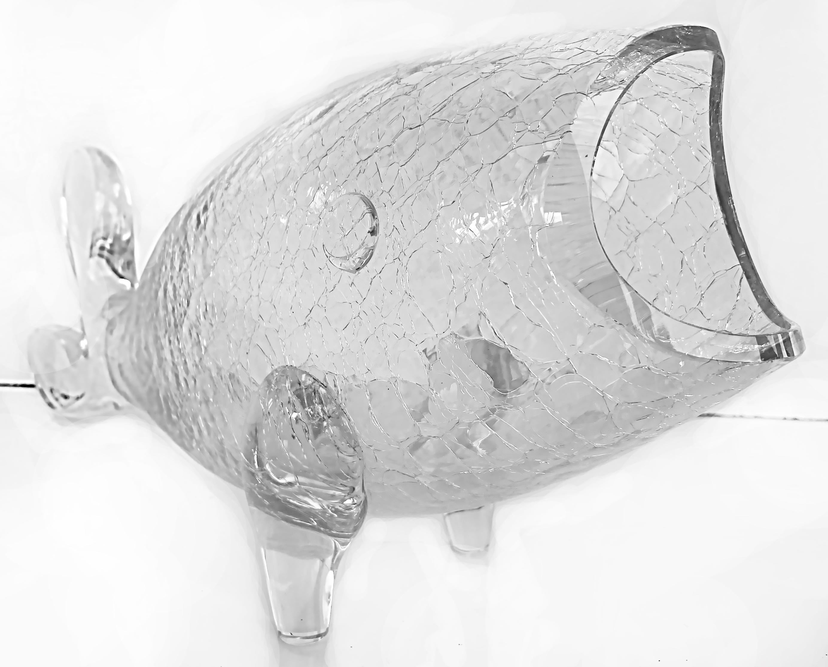 Midcentury blenko crackle glass footed fish sculpture.

Offered 1960s clear crackle-glass footed fish vessel from Blenko. The hand blown fish is rolled on a tree bark form to achieve the texture. The fish is a lovely sculptural object or it can