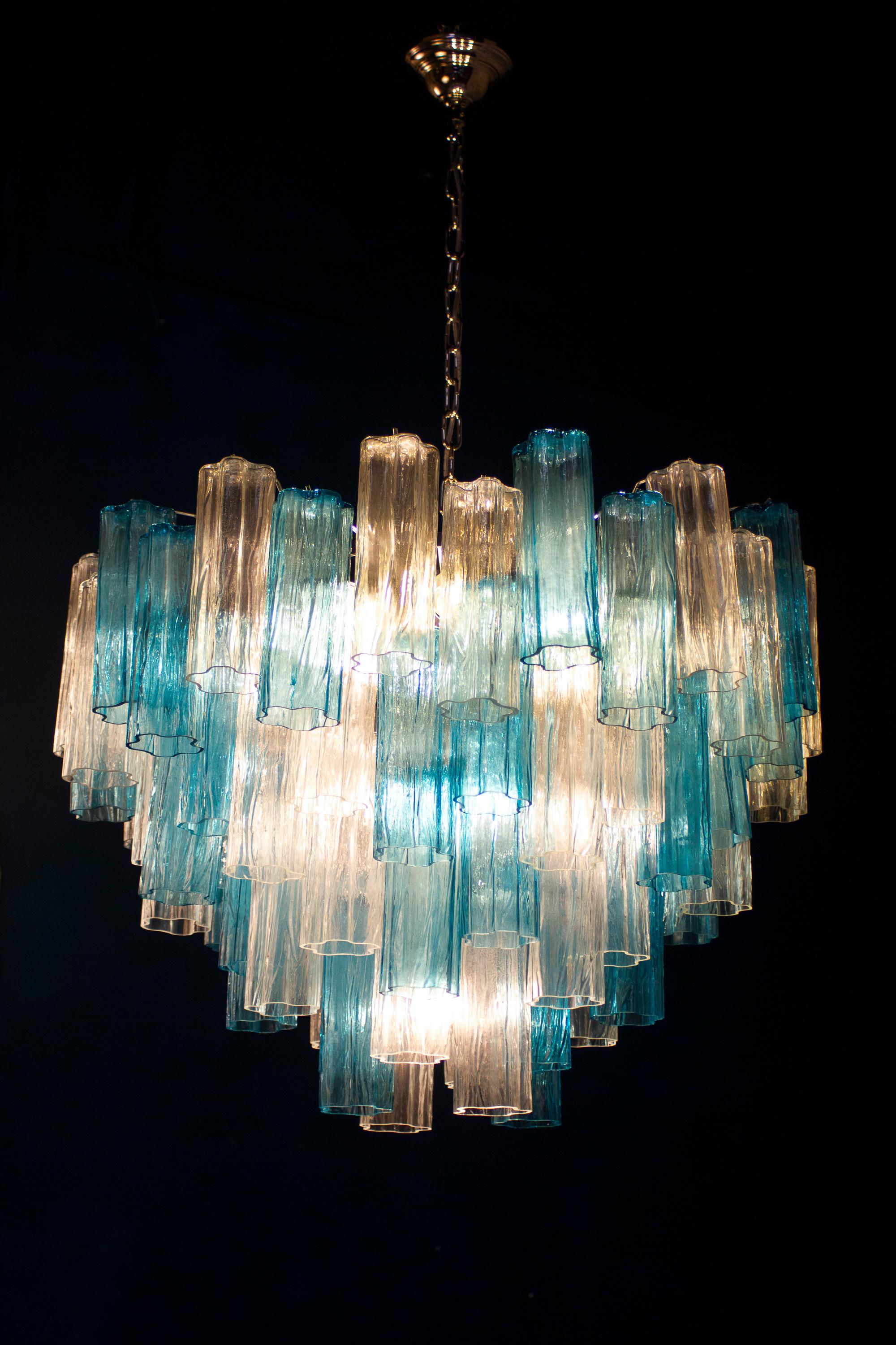 Ce lustre étonnant présente une rare combinaison de couleurs en considérant les verres précieux de Murano de couleur bleu et glace. Chaque lustre est composé de 78 éléments en verre soufflé tronchi soutenus par un cadre chromé.
10 ampoules E