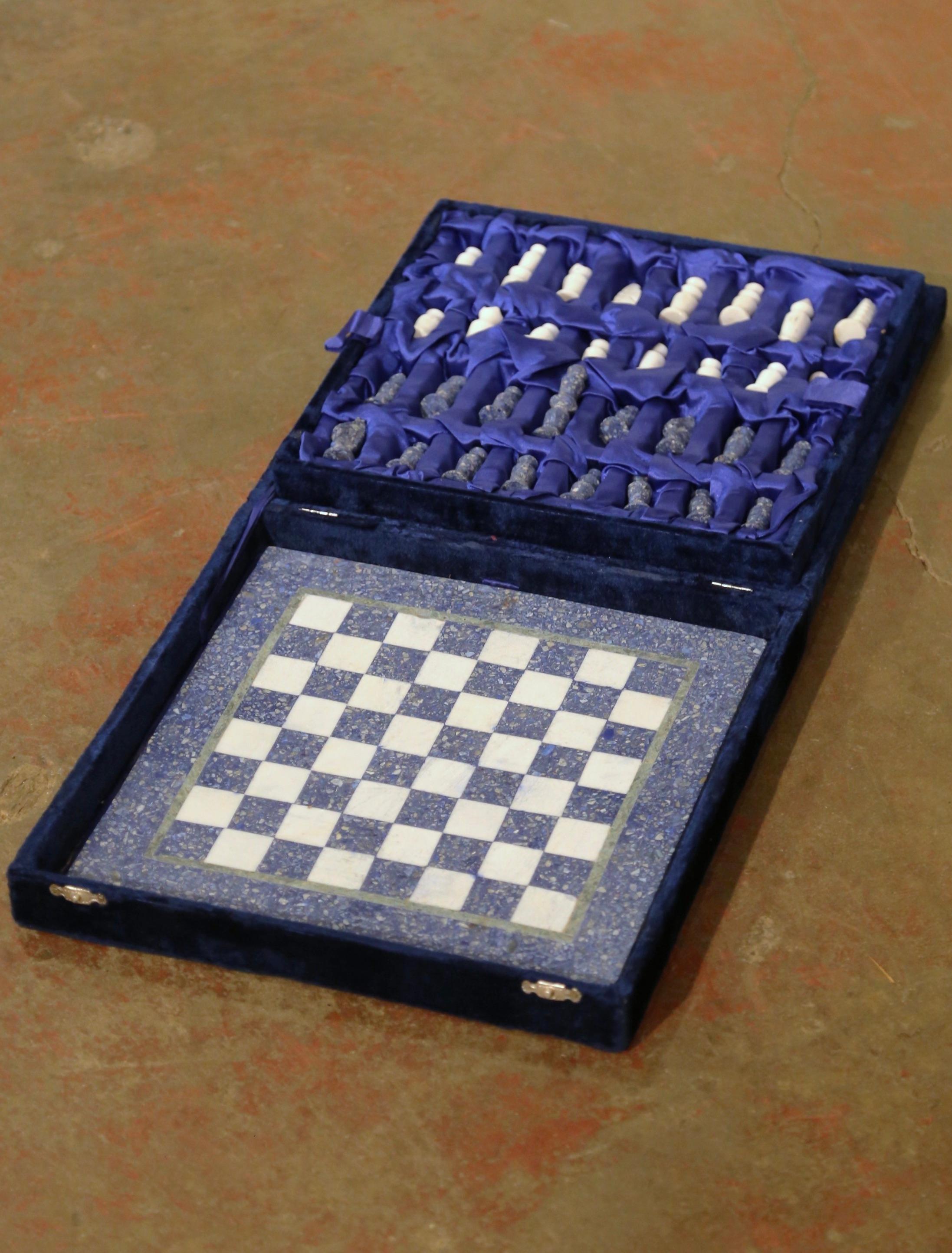 This complete set is skillfully handcrafted, featuring a heavy chess board in blue and white checkers with an olive green rim and thirty-two stone figurine pieces. Half of these pieces are a beautiful conglomerate blue, while the other half is a
