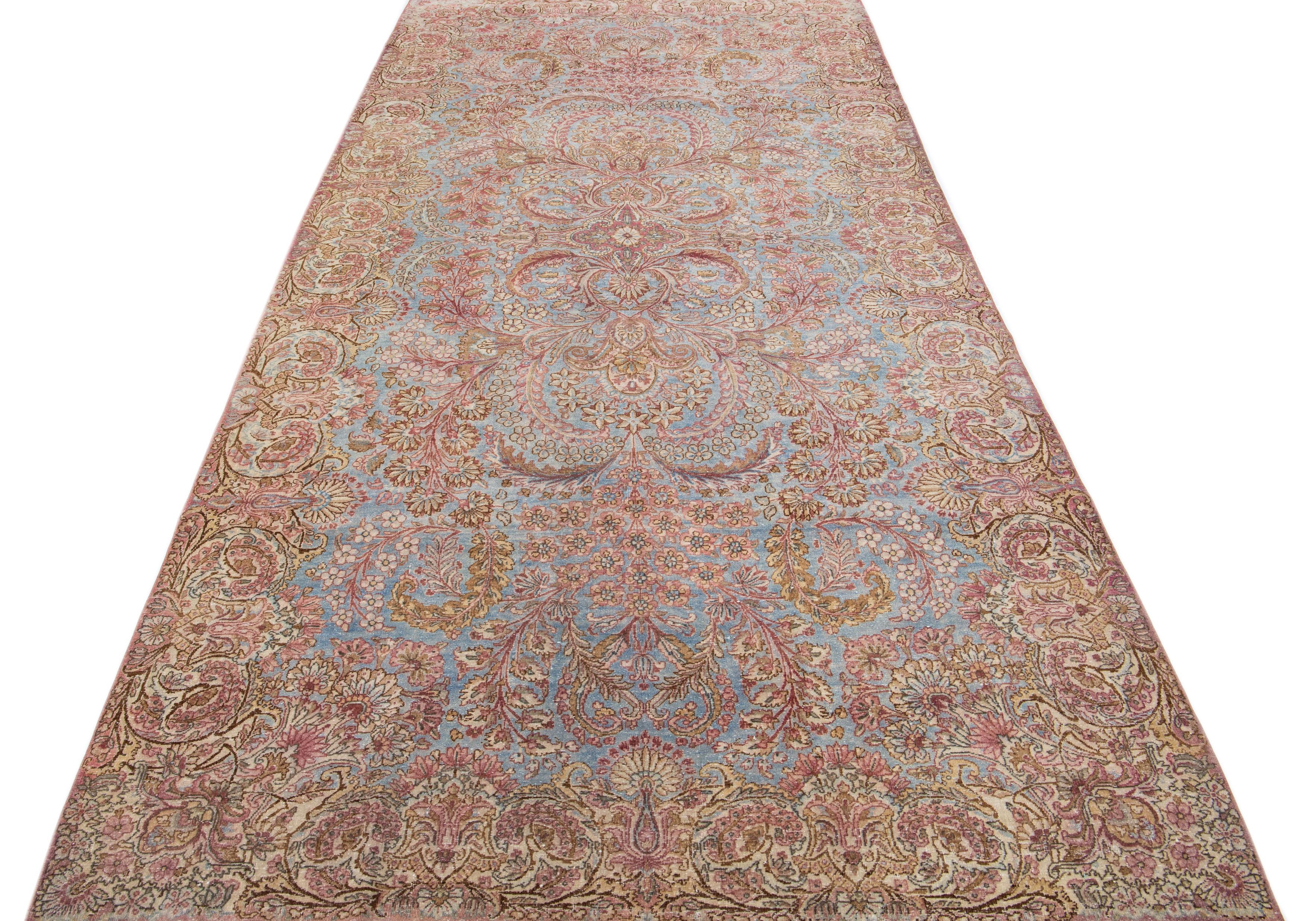 Beautiful antique Kirman hand-knotted wool rug with a blue color field. This Persian rug has beige and pink accents in a gorgeous traditional floral design.

This rug measures 5'9