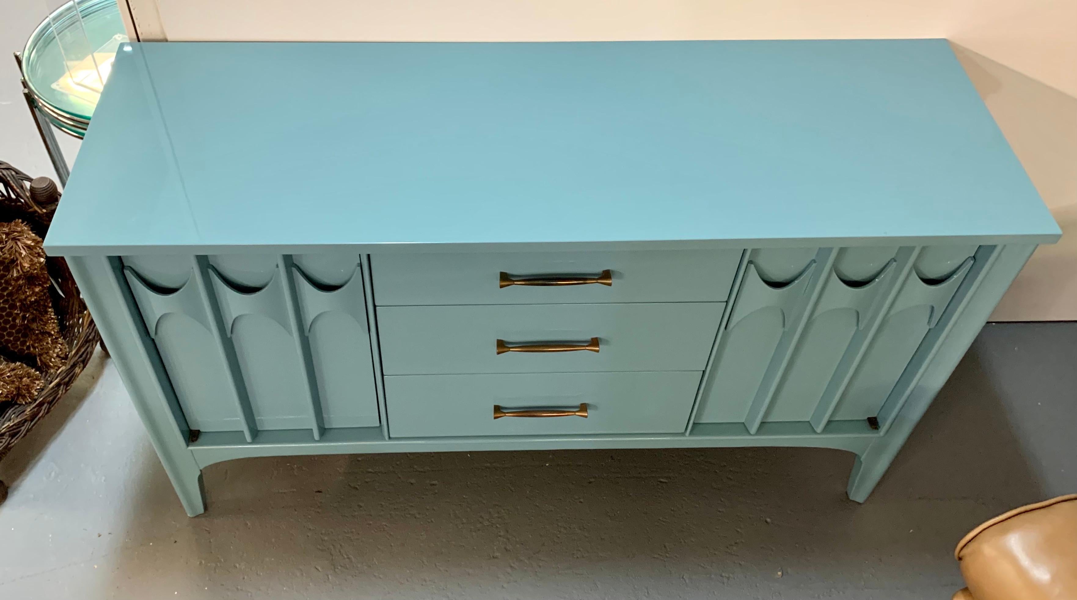 Mid century credenza buffet sideboard newly lacquered in a robin’s egg blue color. It has three center drawers and two side doors with sculptural fronts.