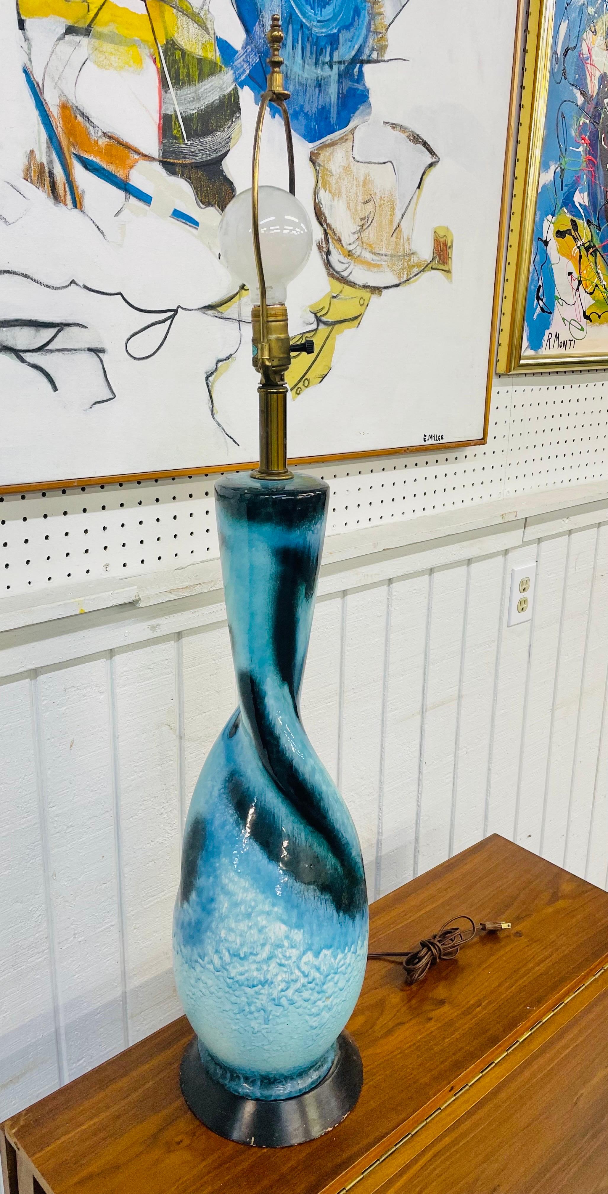 Cette annonce concerne une lampe de table en céramique de style Lava Pottery bleu du milieu du siècle. Avec un mélange de bleus, une base noire, une quincaillerie en laiton et un cordon d'origine.