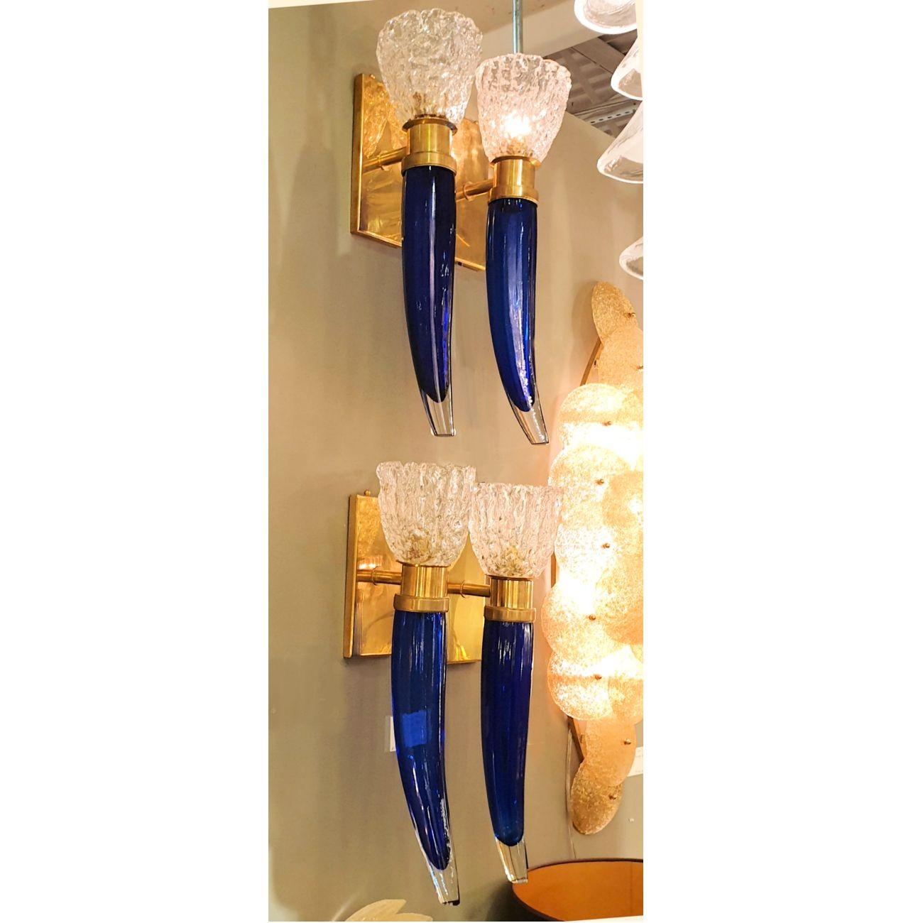 Pair of large Mid-Century Modern Murano glass wall sconces, attributed to Seguso, circa 1970s.
Two pairs of sconces available - set of four sconces : priced and sold by pair.
The vintage sconces are made of brass mounts and handmade Murano glass