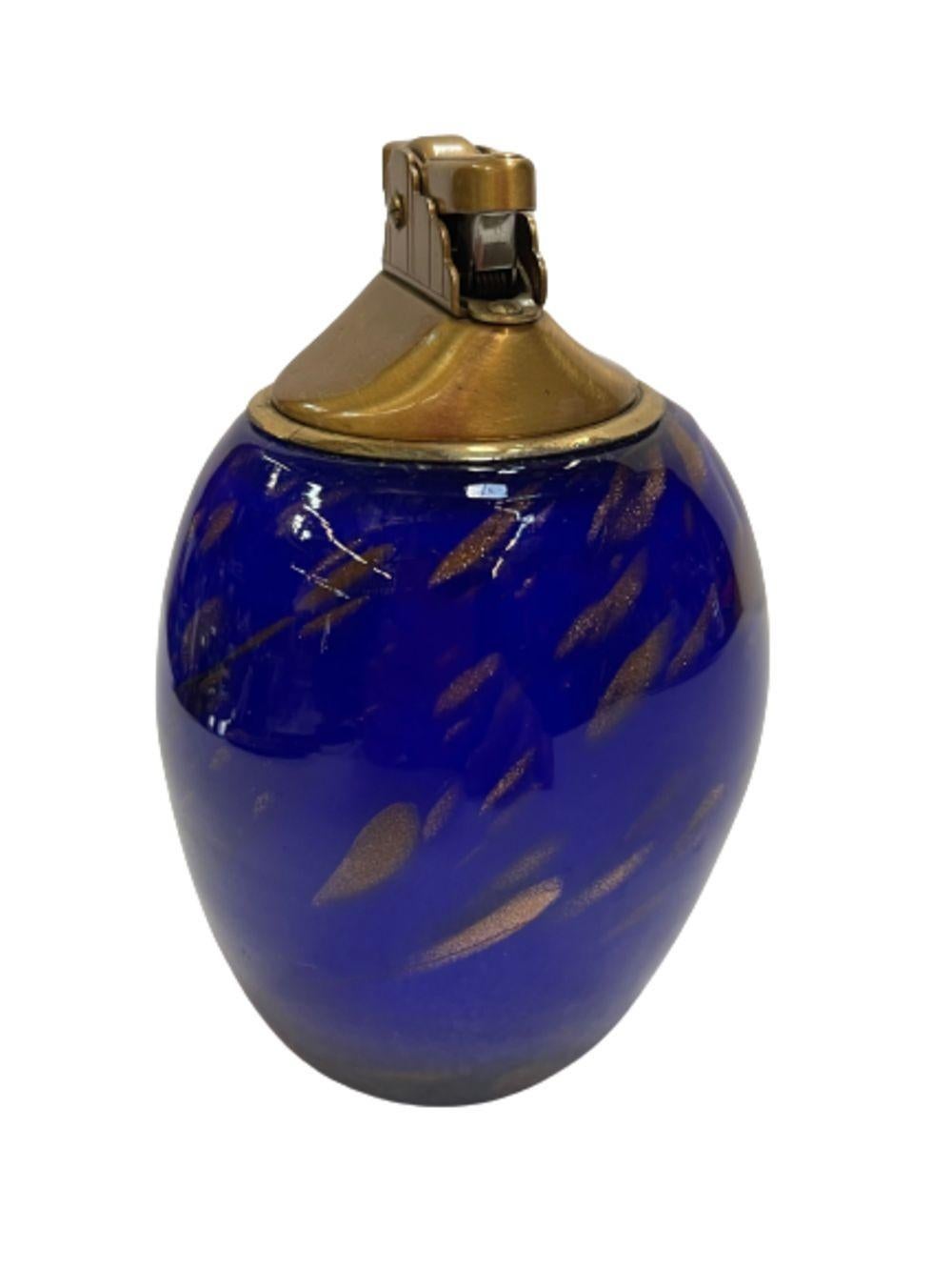 Original blue murano glass with gold leaf table lighter. This lighter features hand-crafted and polished dark ocean blue glass with gold leaf accents throughout, the lighter mechanism is cast in brass.
Made in Italy, circa 1960.