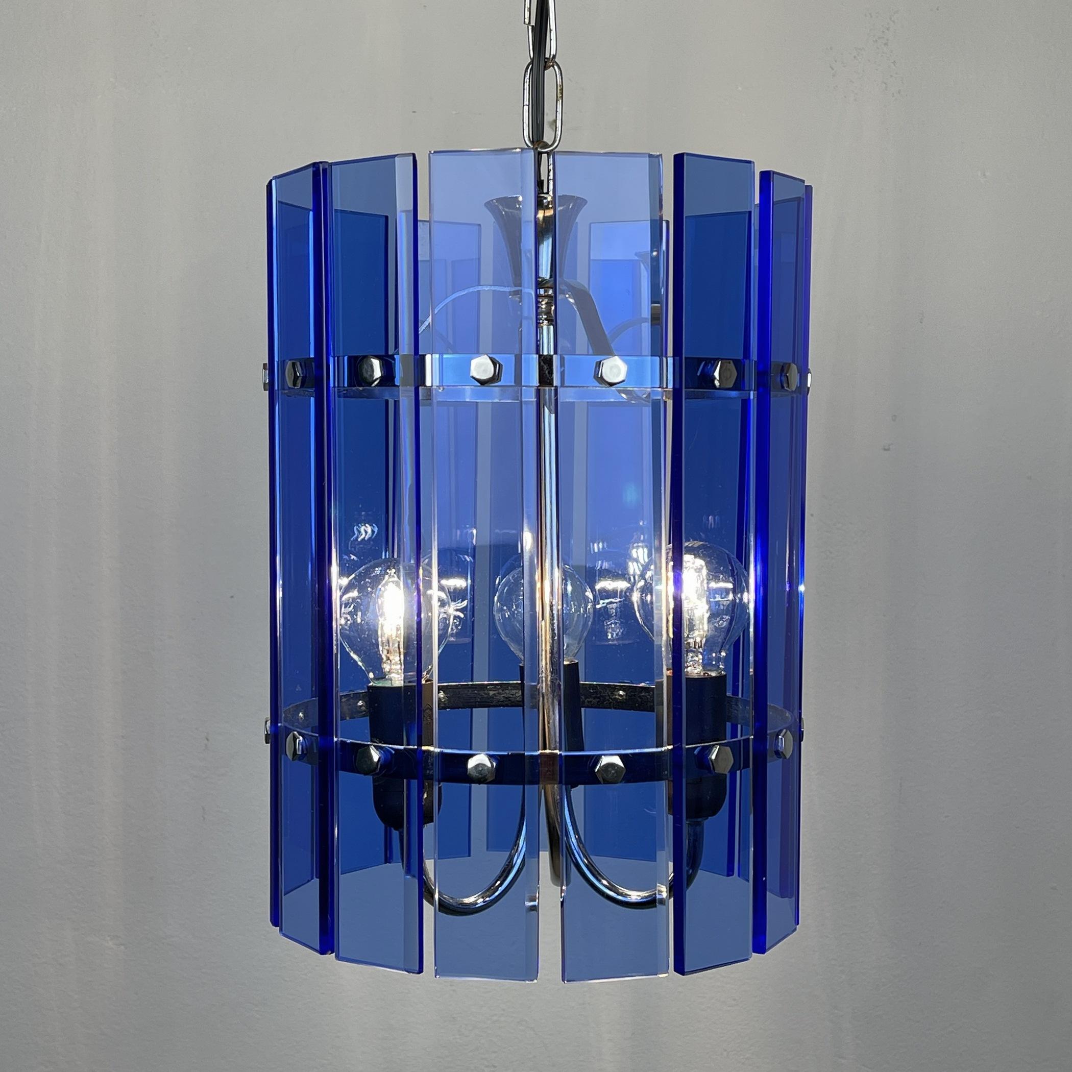 The beautiful vintage pendant lamp Veca Fontana Arte, chrome, and blue glass, sputnik, atomic, vintage Italian, 3 lamp chandelier, pendant, or ceiling light from the 1960s made in Italy. The shades, in blue-colored glass, are in excellent condition.