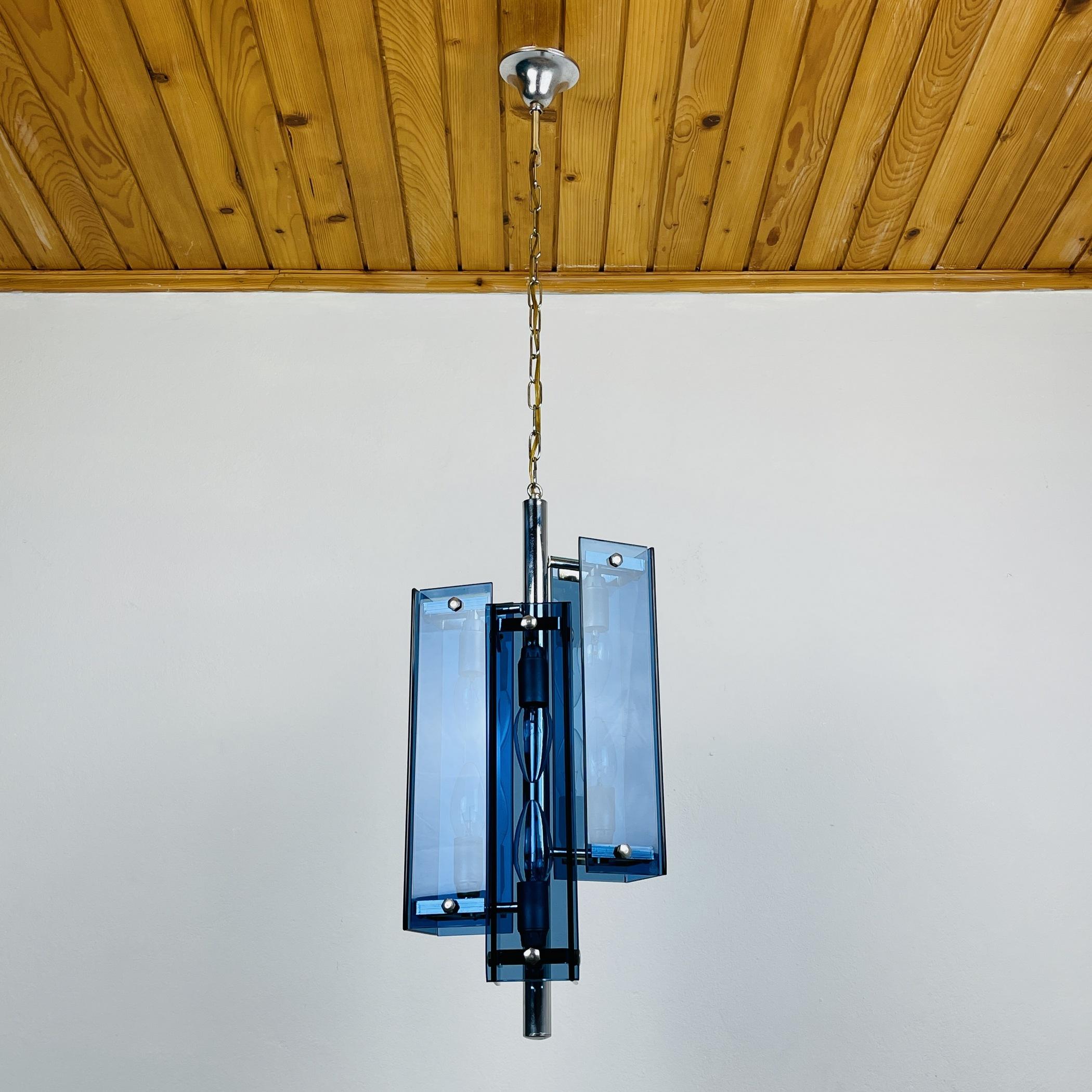 The beautiful vintage pendant lamp Veca Fontana Arte, chrome, and blue glass, sputnik, atomic, vintage Italian, 6 lamp chandelier, pendant, or ceiling light from the 1960s made in Italy. The light chambers face both up and down, so out of 3 branches