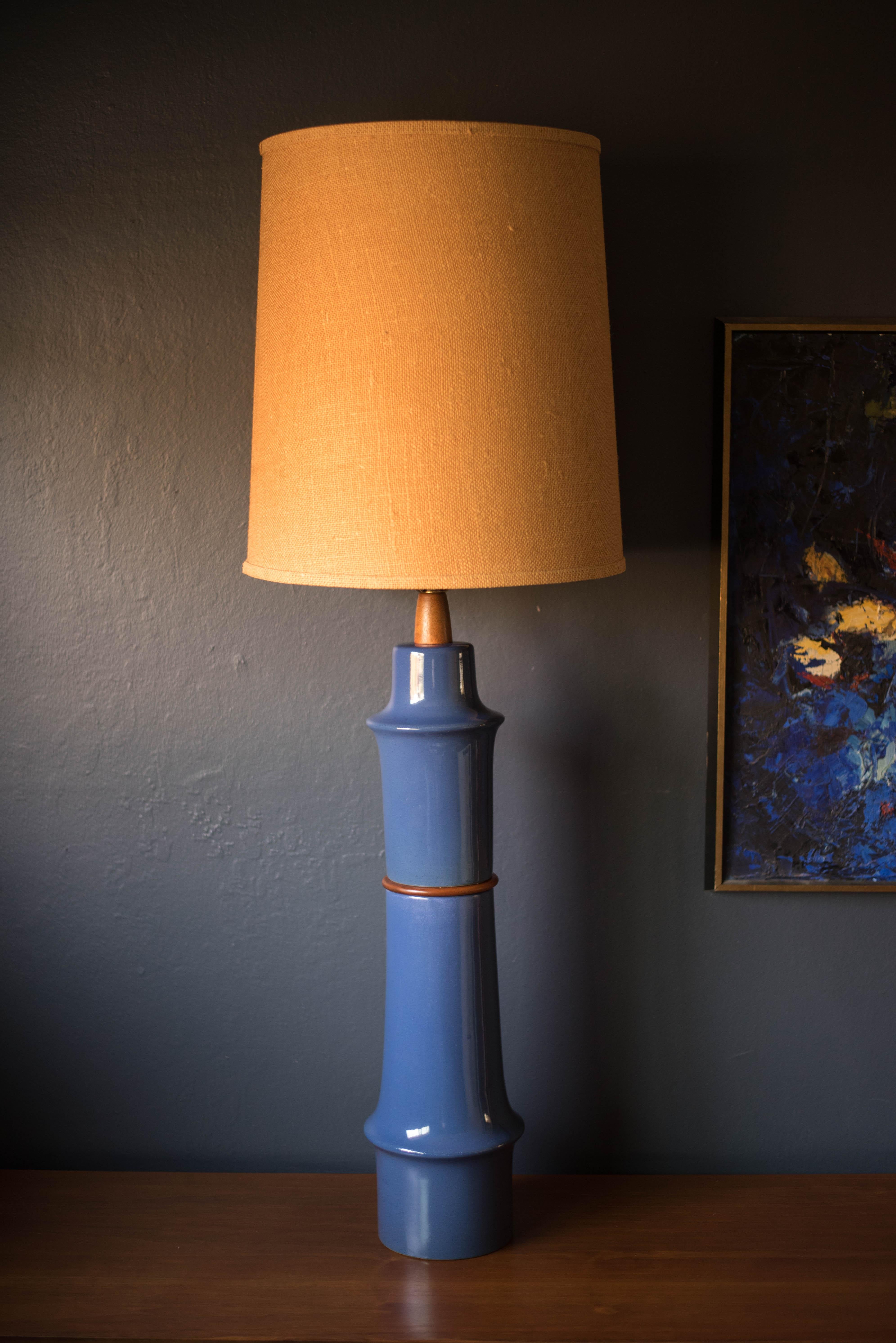 Mid-century ceramic and walnut lamp by Gordon and Jane Martz for Marshall Studios. This oversized lamp features a sculptural stacked form with a glossy deep blue glaze finish. Includes a three way switch mechanism and burlap drum shade.