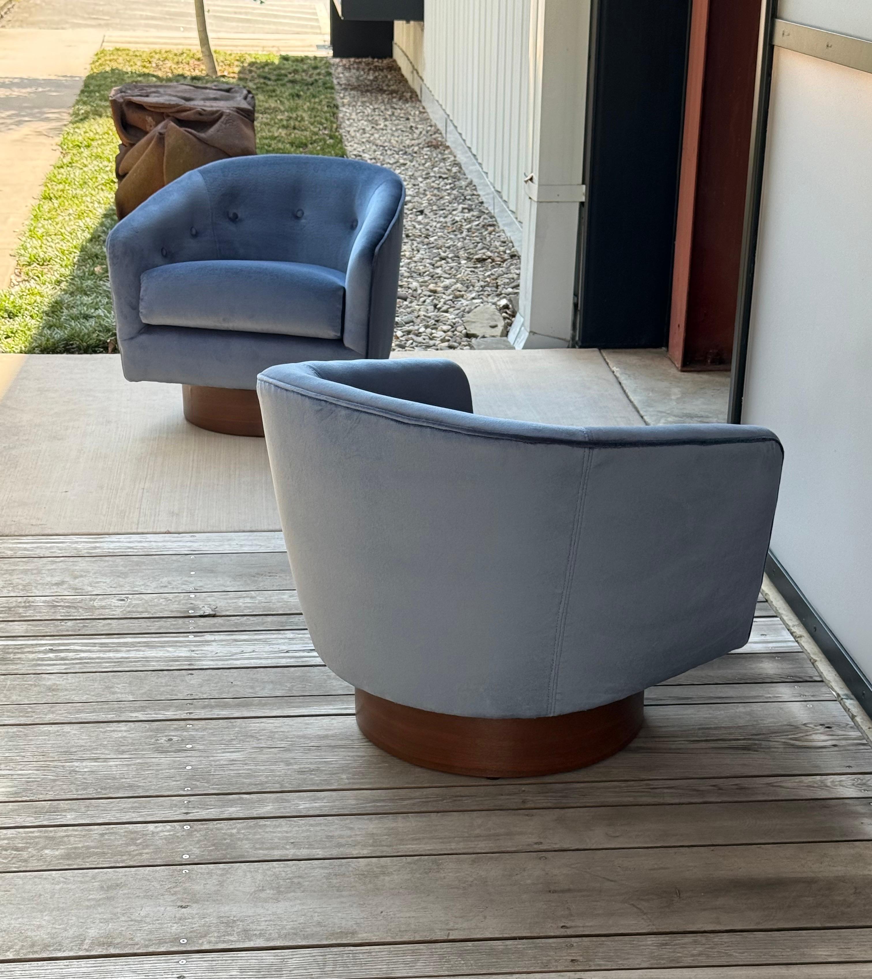 Chaises pivotantes du milieu du siècle, conçues par Milo Baughman pour Thayer Coggin. Cette paire repose sur des socles arrondis qui pivotent. Les éléments arrondis se poursuivent dans la chaise avec son dossier et ses accoudoirs arrondis.

Cette