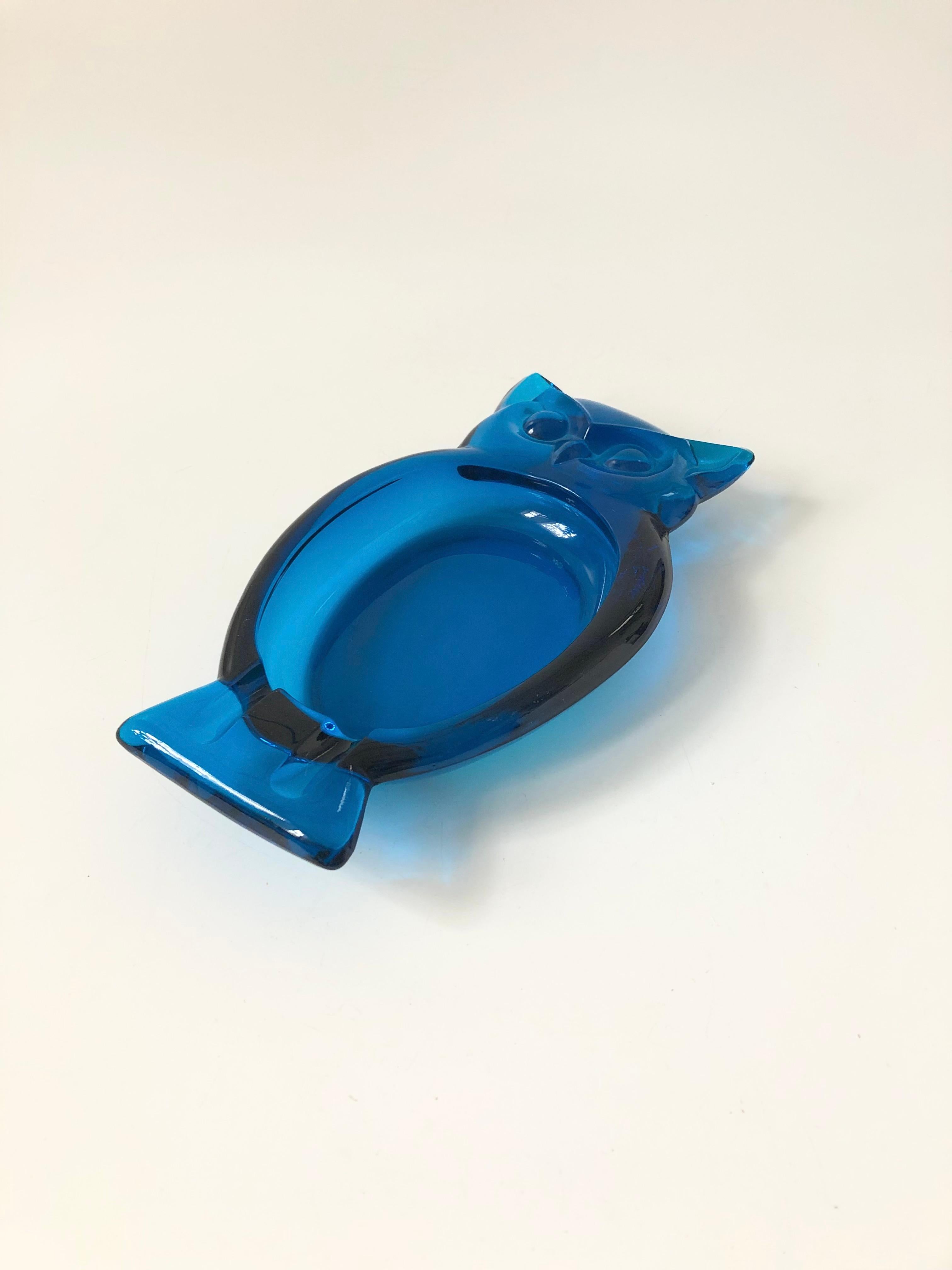 A mid century glass ashtray in the shape of an owl. Made by Viking glass in a vibrant blue color. Nice larger size, perfect for using as a catch all tray.
  