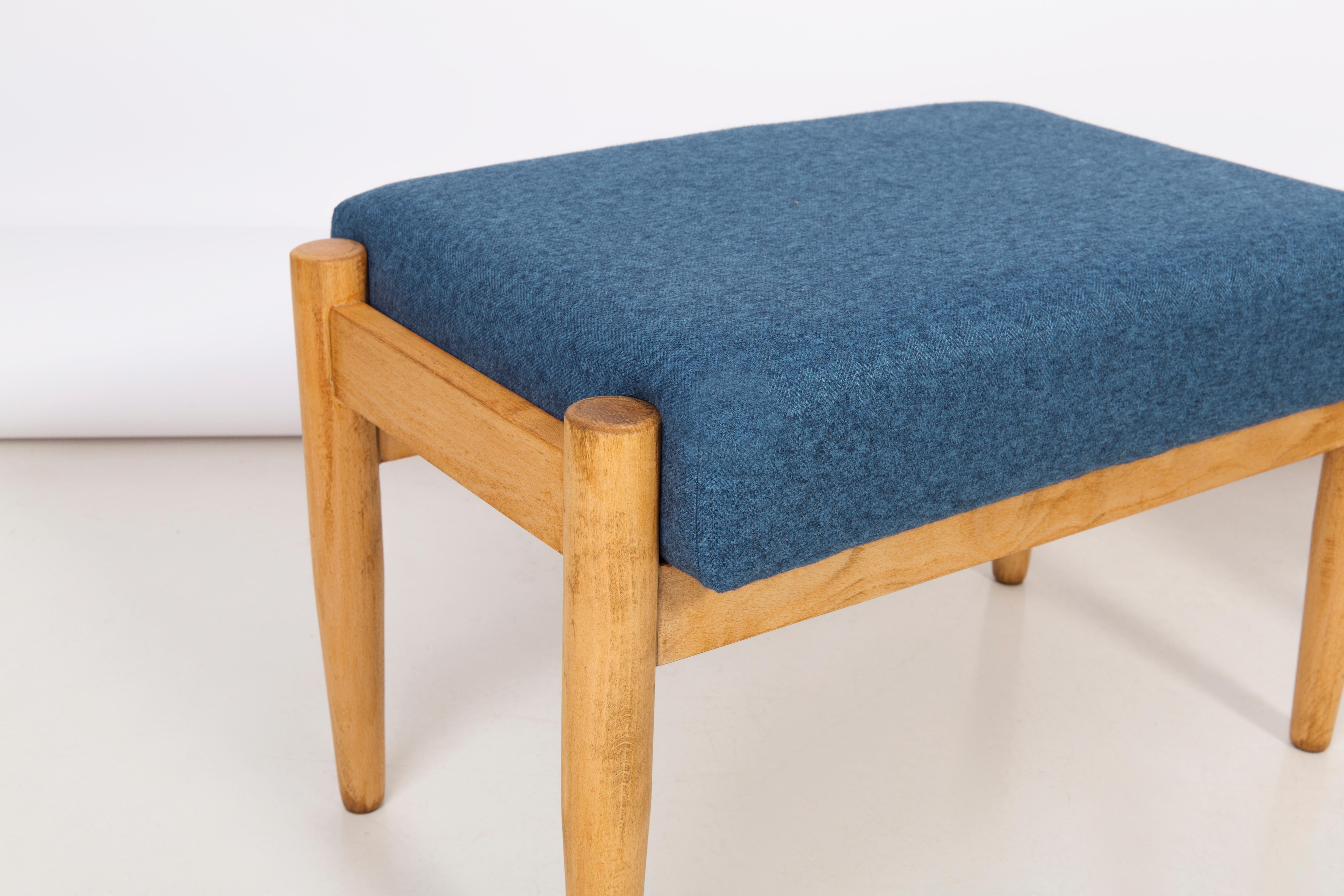 Hocker aus der Zeit um die 1960er Jahre. Schöne blaue hochwertige Polsterung. Der Hocker besteht aus einem gepolsterten Teil, einer Sitzfläche und sich nach unten verjüngenden Holzbeinen, die für den Stil der 1960er Jahre charakteristisch sind. Wir