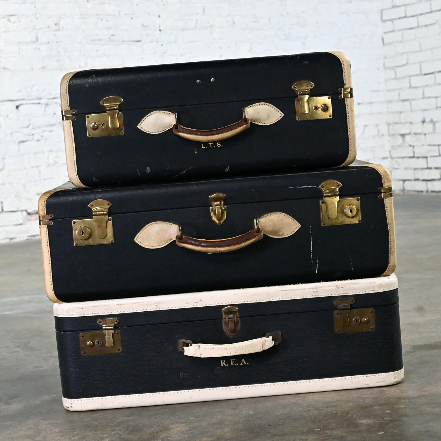 Handsome vintage Boho Chic luggage suitcase end or side table or décor comprised of black & white leather, plastic, and brass plated hardware & handles and blue fabric interiors.  Beautiful condition, keeping in mind that these are vintage and not