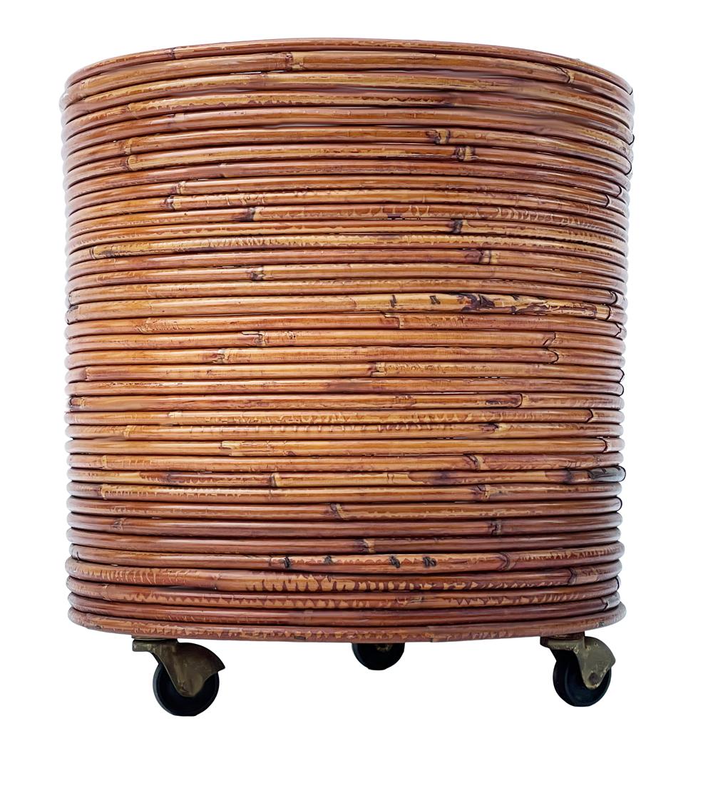 A classic retro planter or trash can circa 1970s. It features rattan & wood construction on casters. Clean & ready to use.
