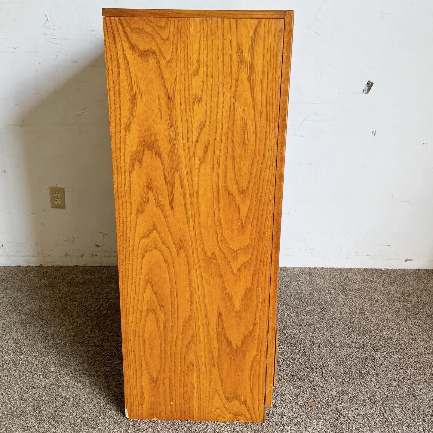 Embrace mid-century elegance with this Boho Wicker Highboy Dresser by Dixie Furniture. Crafted in the 1970s, this piece features rich wooden tones and intricately woven wicker drawer fronts, embodying the bohemian style. With five spacious drawers,
