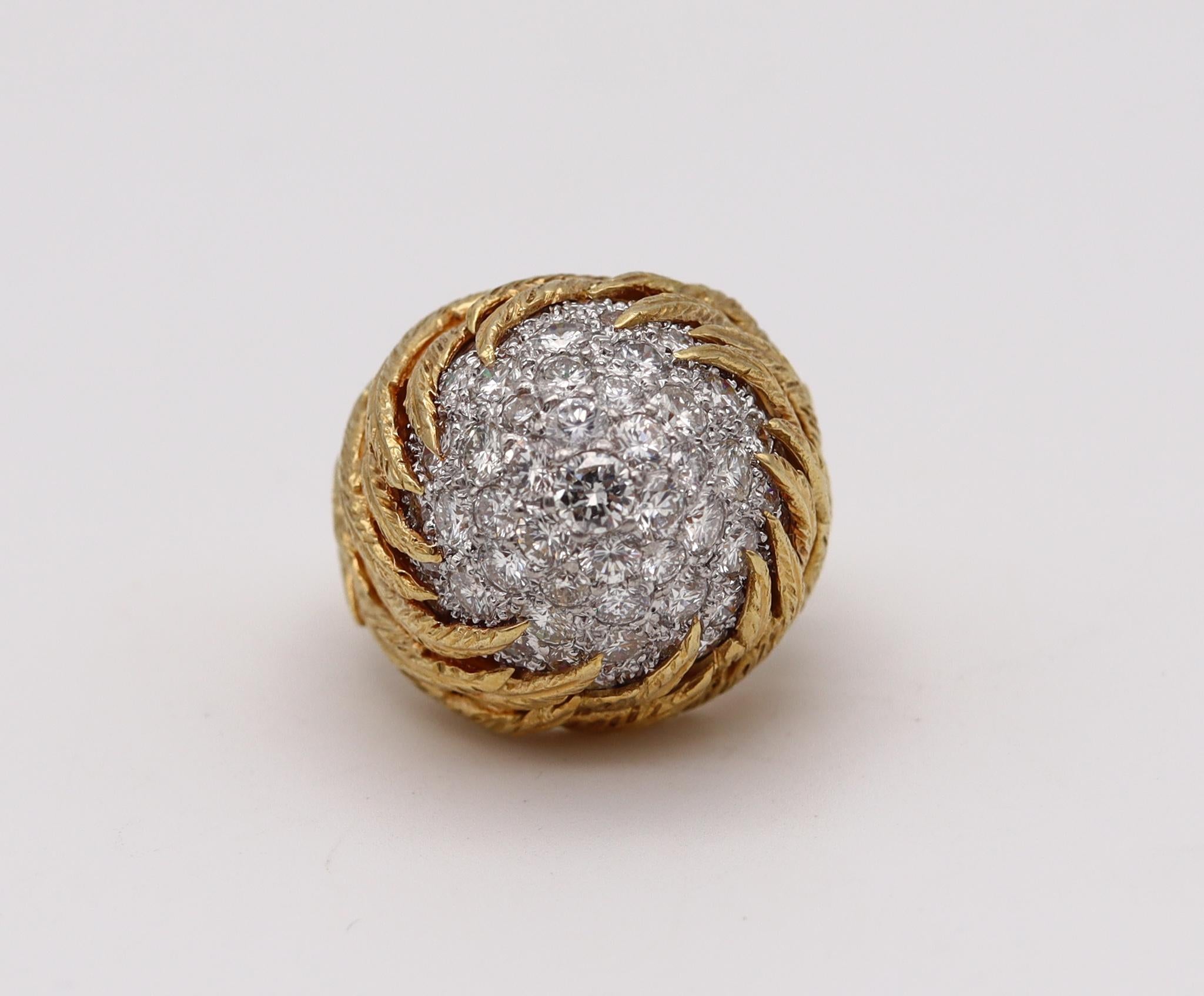 An Italian gem set bombe ring.

Beautiful sculpted piece, created in Milano Italy during the post war and the mid century periods, back in the 1960. This bombe cocktail ring has been crafted with a textured feathers patterns in solid yellow gold of