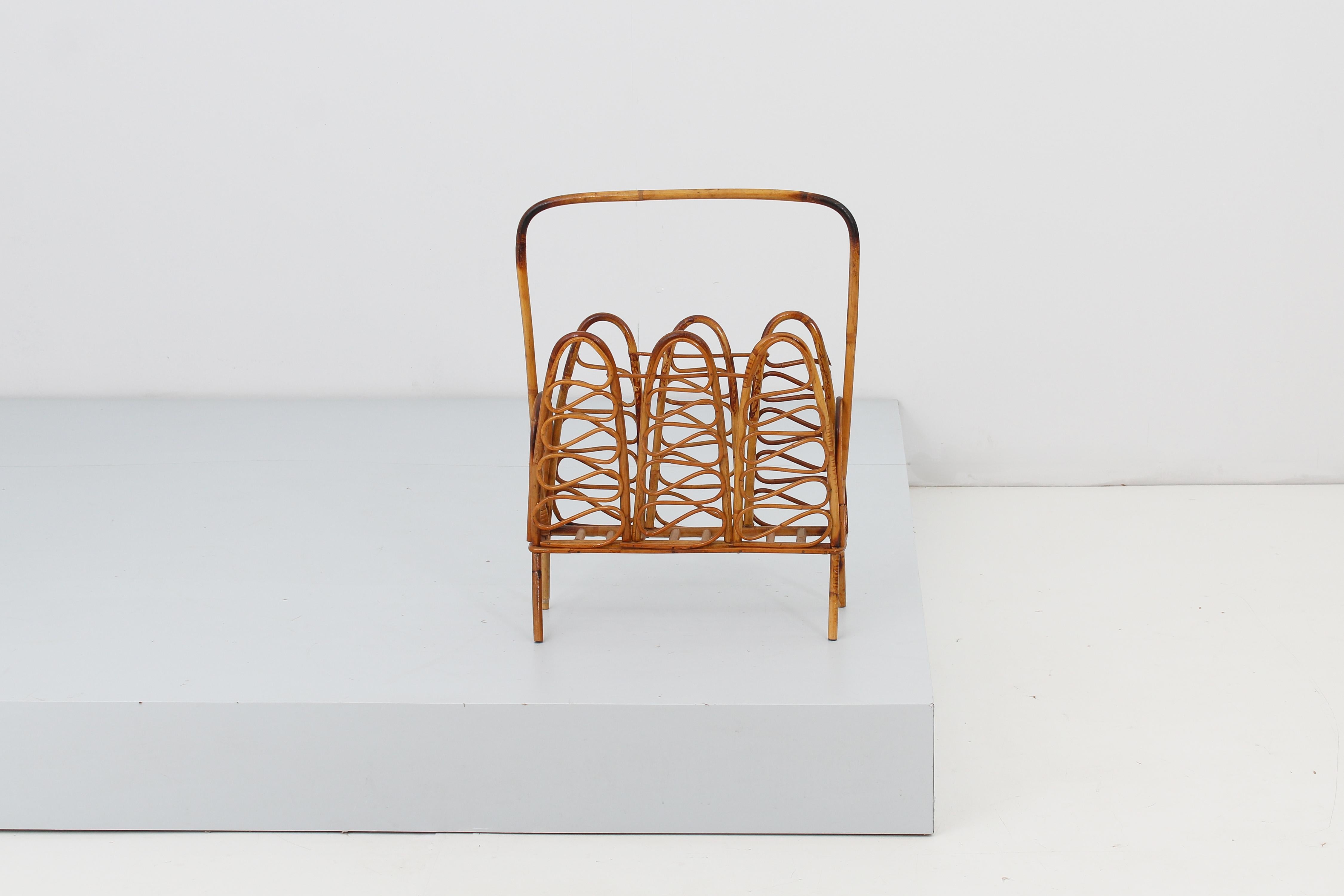 Stylish magazine rack in straight and curved bamboo canes and wicker bands with curved handle. Attributed to Bonacina, Italian manufacture in the 60s.
Wear consistent with age and use.