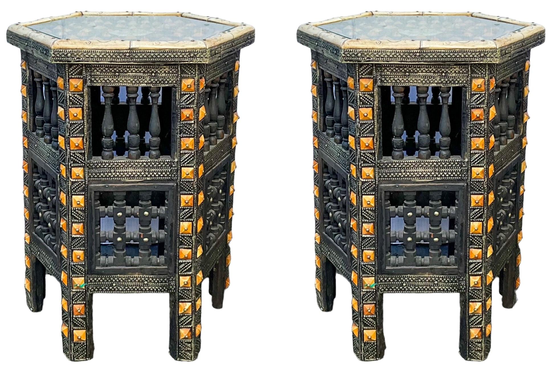 This is a pair of heavily carved hexagon form teak and bone inlaid Moroccan side tables. They most likely date to at least the 1950s or earlier. They are both in very good condition.