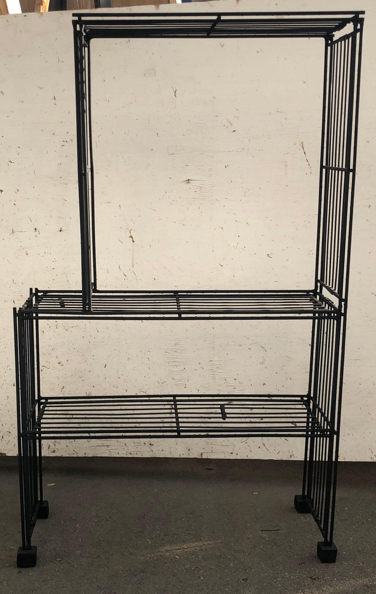 The Mid Century Book Case & Display epitomizes a captivating fusion of industrial pragmatism and postmodern innovation. Crafted from sleek black iron, this storage rack channels the robustness of the industrial era while embracing the bold and