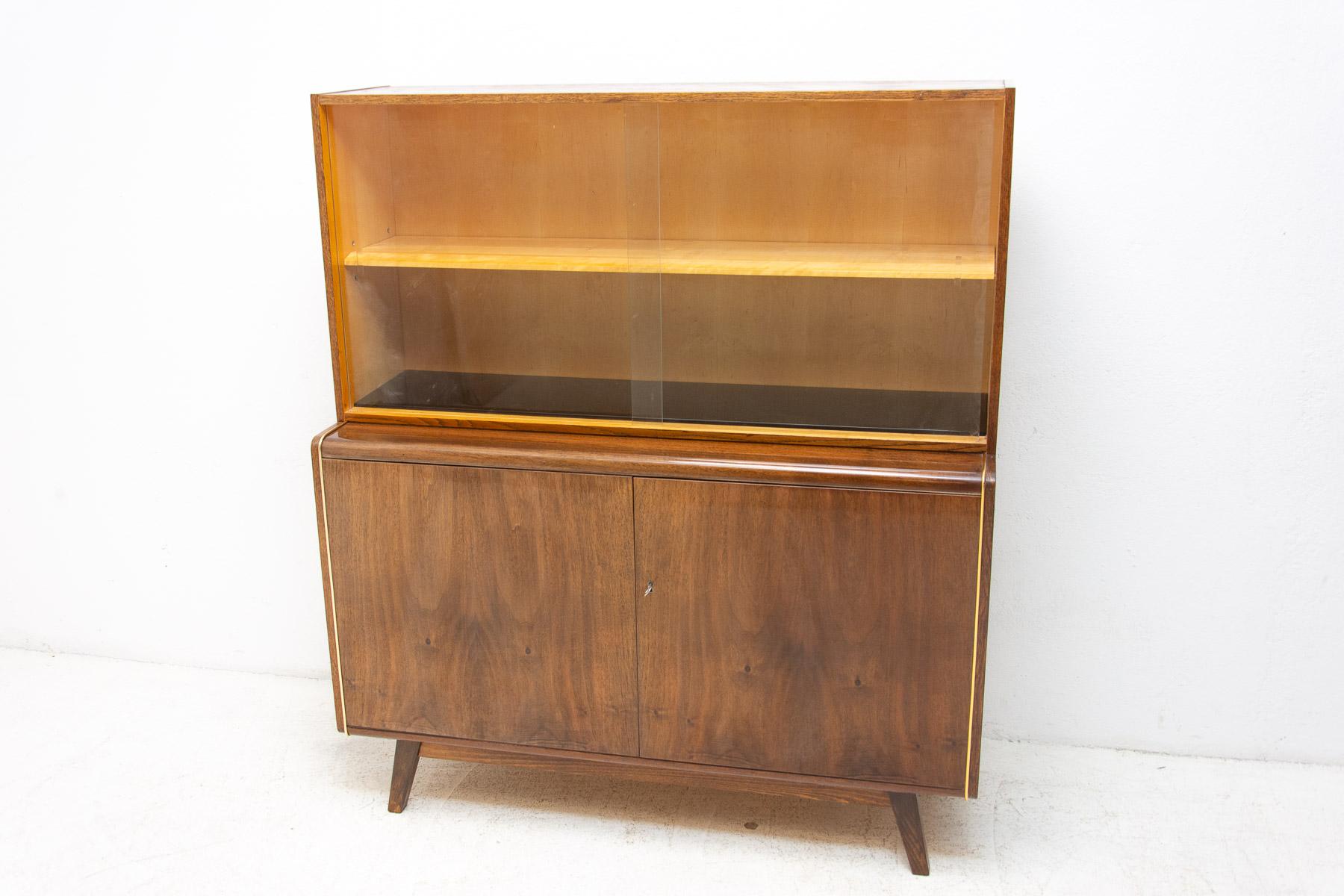 Mid century Vintage bookcase from the 1960´s. It was designed by Hubert Nepožitek & Bohumil Landsman for Jitona in the former Czechoslovakia. Features a simple design, a glazed section with a storage spaces. Nice walnut veneer. In very good Vintage