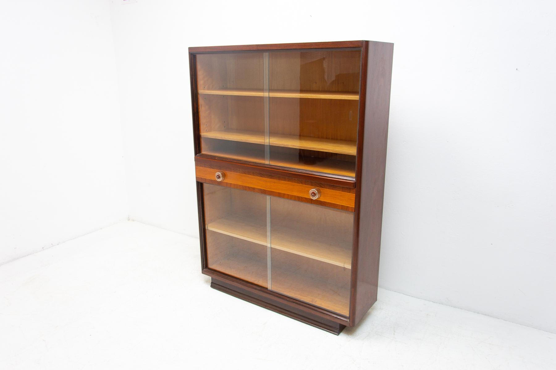 Mid century bookcase/library designed by Jindrich Halabala for UP Závody. It was made in the 1950´s in the former Czechoslovakia. Features a simple design, a glazed section with four storage spaces and one drawer. In Very good condition. Beautiful