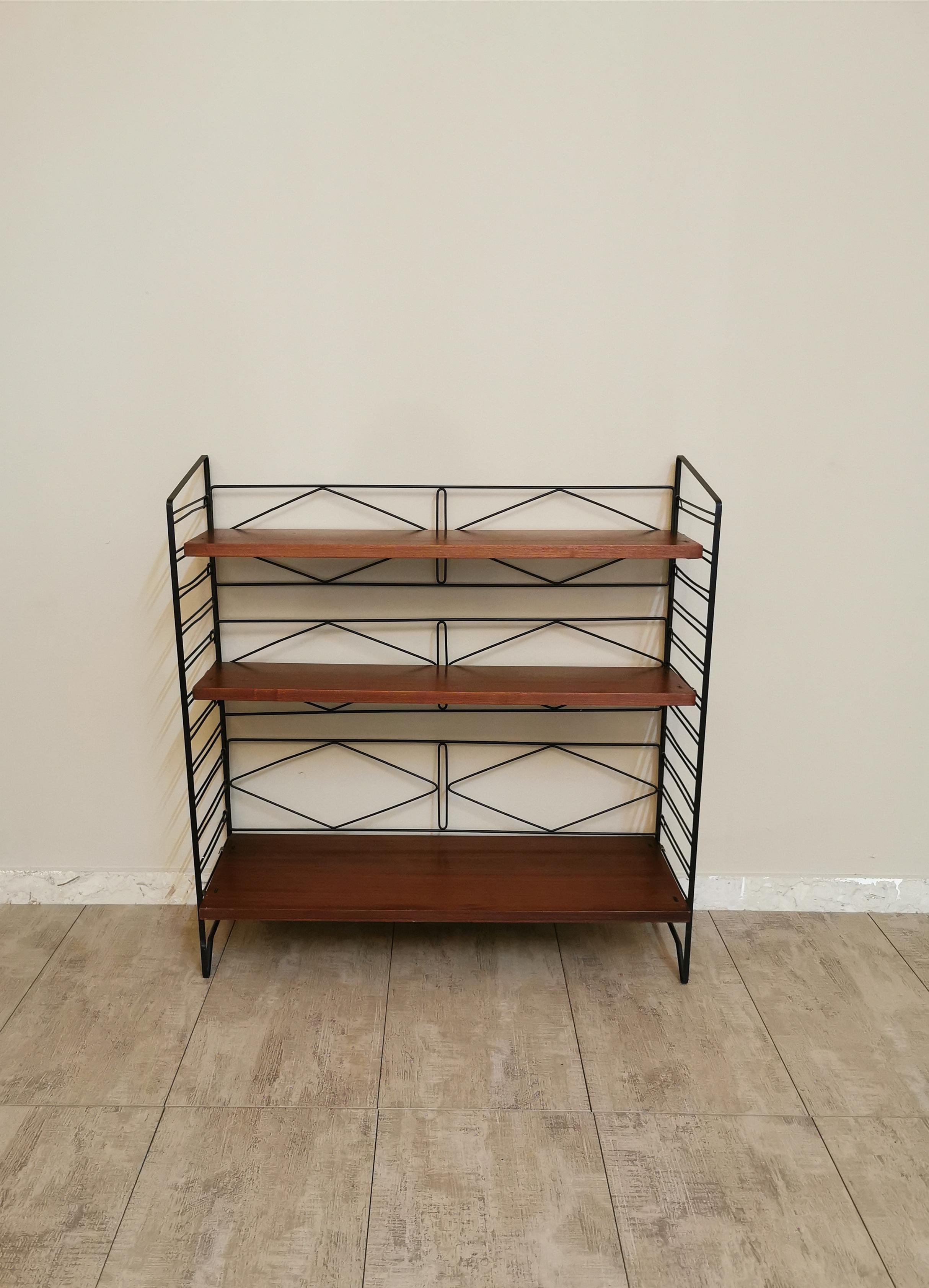 Small wall bookcase with a particular structure entirely in black enamelled metal with hooks that support 3 shelves in teak wood. Italian production of the 1960s.