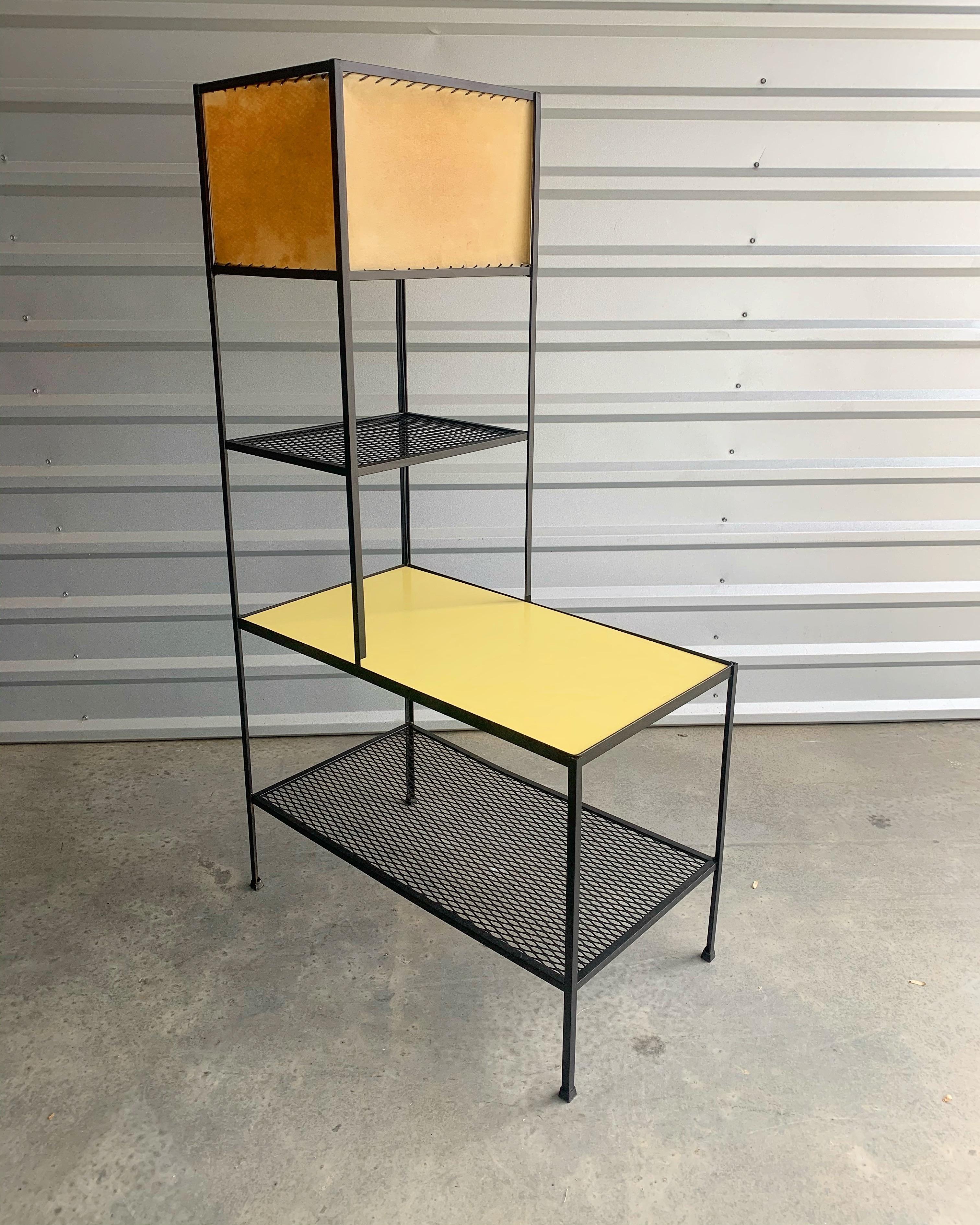 Frederick Weinberg display shelving integrating a lamp using iron, parchment and Formica. All original. Seldom seen original tabletop with reversible Formica; bright white on one side and a gorgeous chartreuse on the other.
Angle iron and mesh