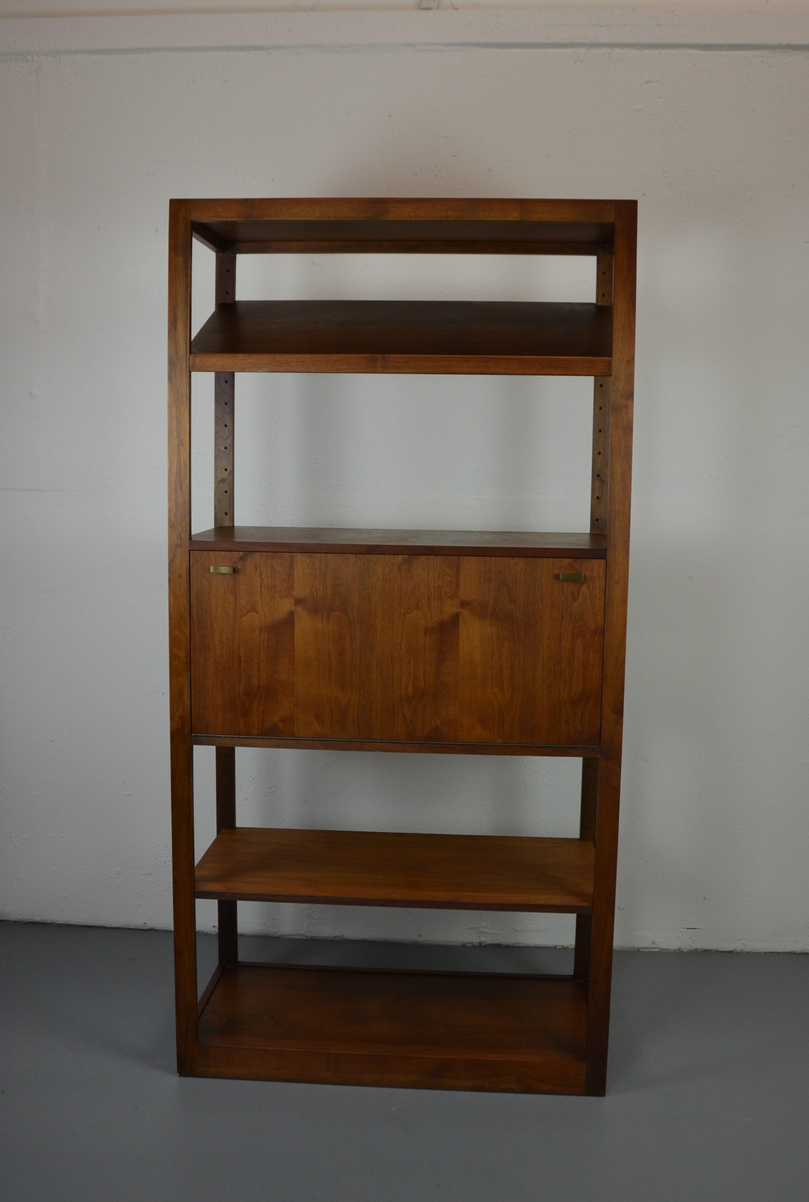 Mid-century bookshelf with adjustable shelves. The cabinet door opens to a bar , a small desk or storage.