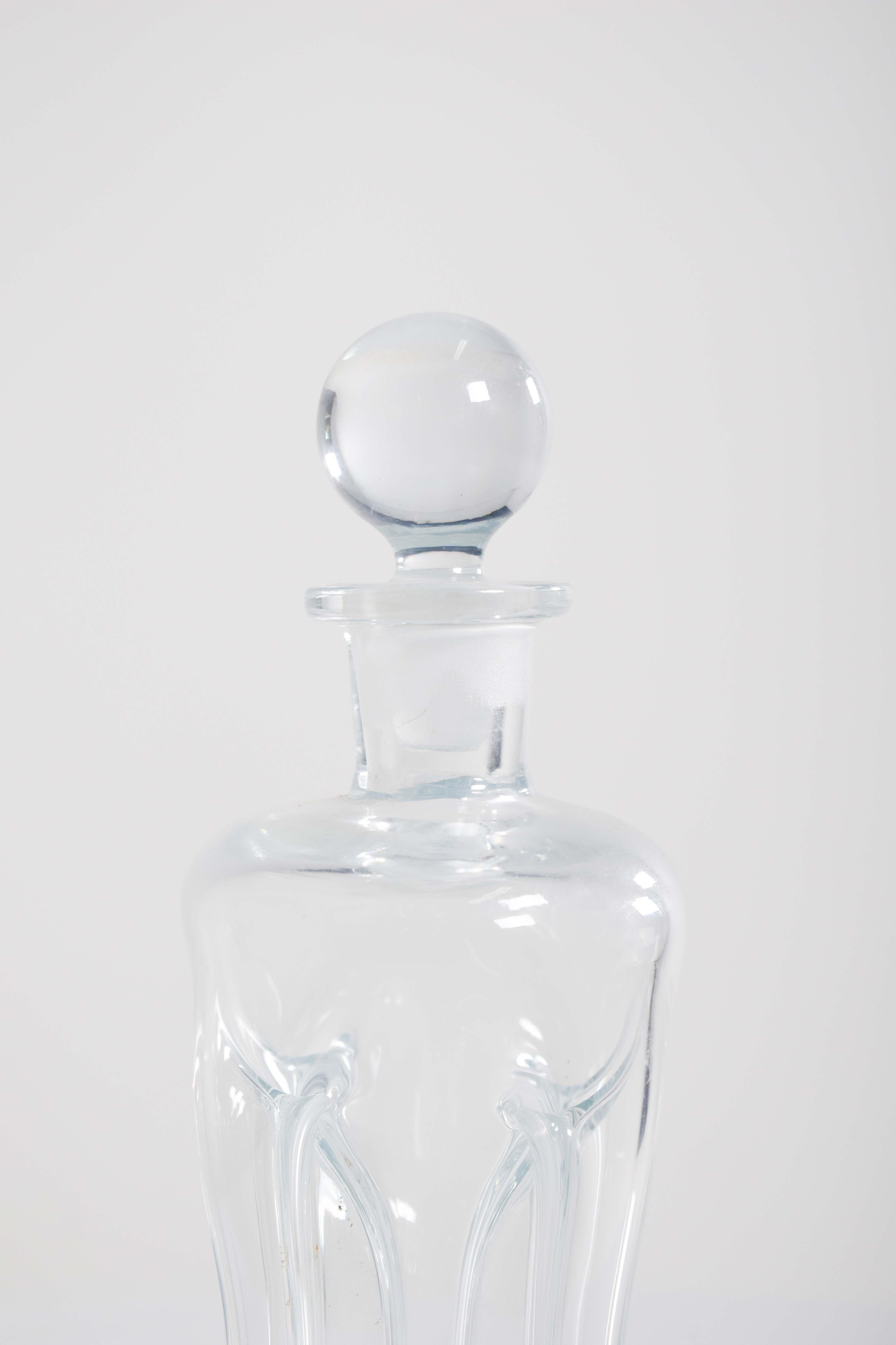 This bottle of liquor/wine, crafted from cut glass, is a sophisticated and elegant piece designed to make a statement. The bottle itself has sharp, clean lines and a ball cap. The cut glass creates a beautifully faceted surface that reflects light