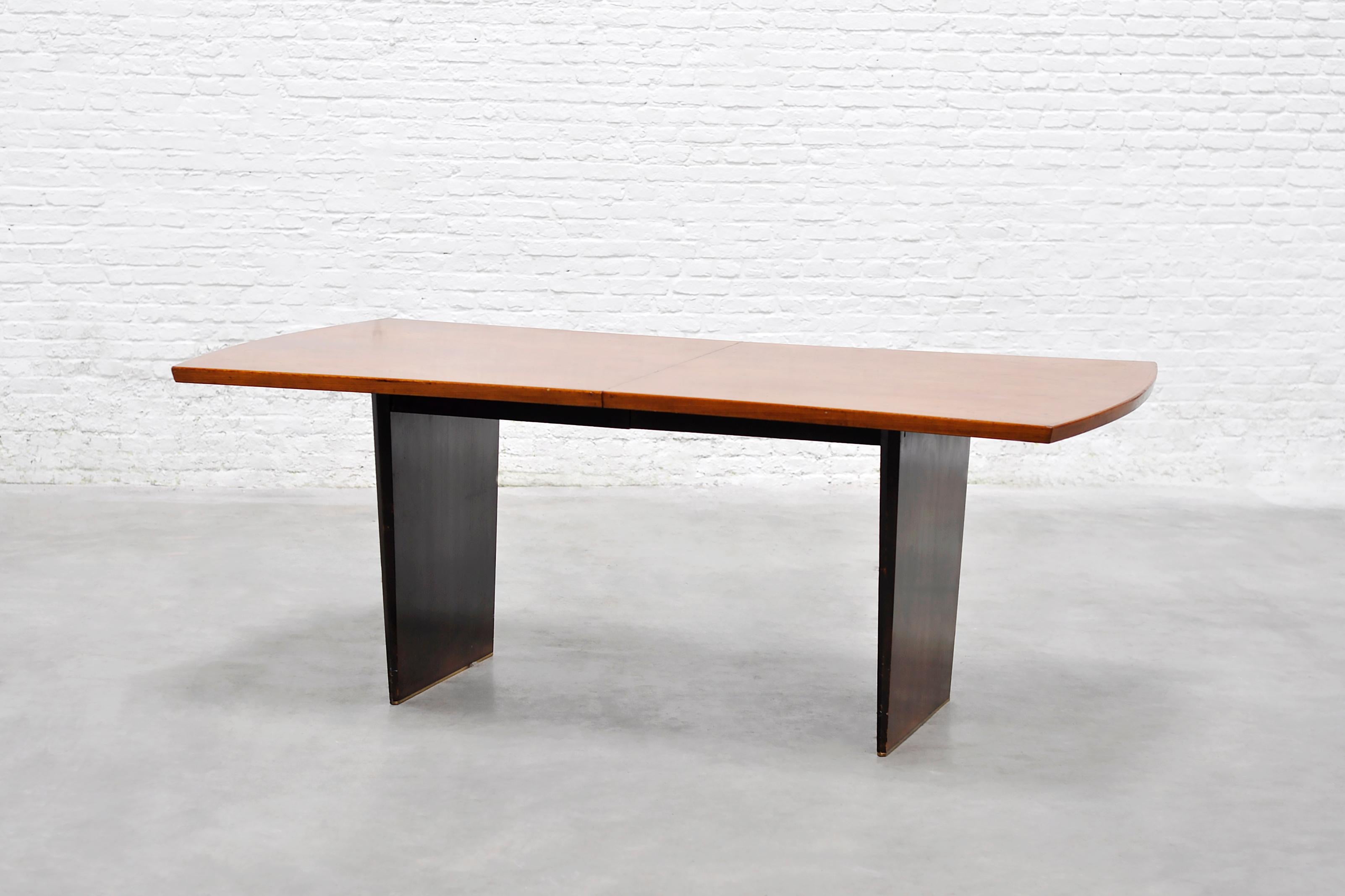 A refined dining table designed by Harvey Probber and produced by Harvey Probber, Inc., USA, circa 1955. Sometimes referred to as the “Bow-Tie” table, this piece features a gently curved warm teak top, resting on tapered dark stained legs capped