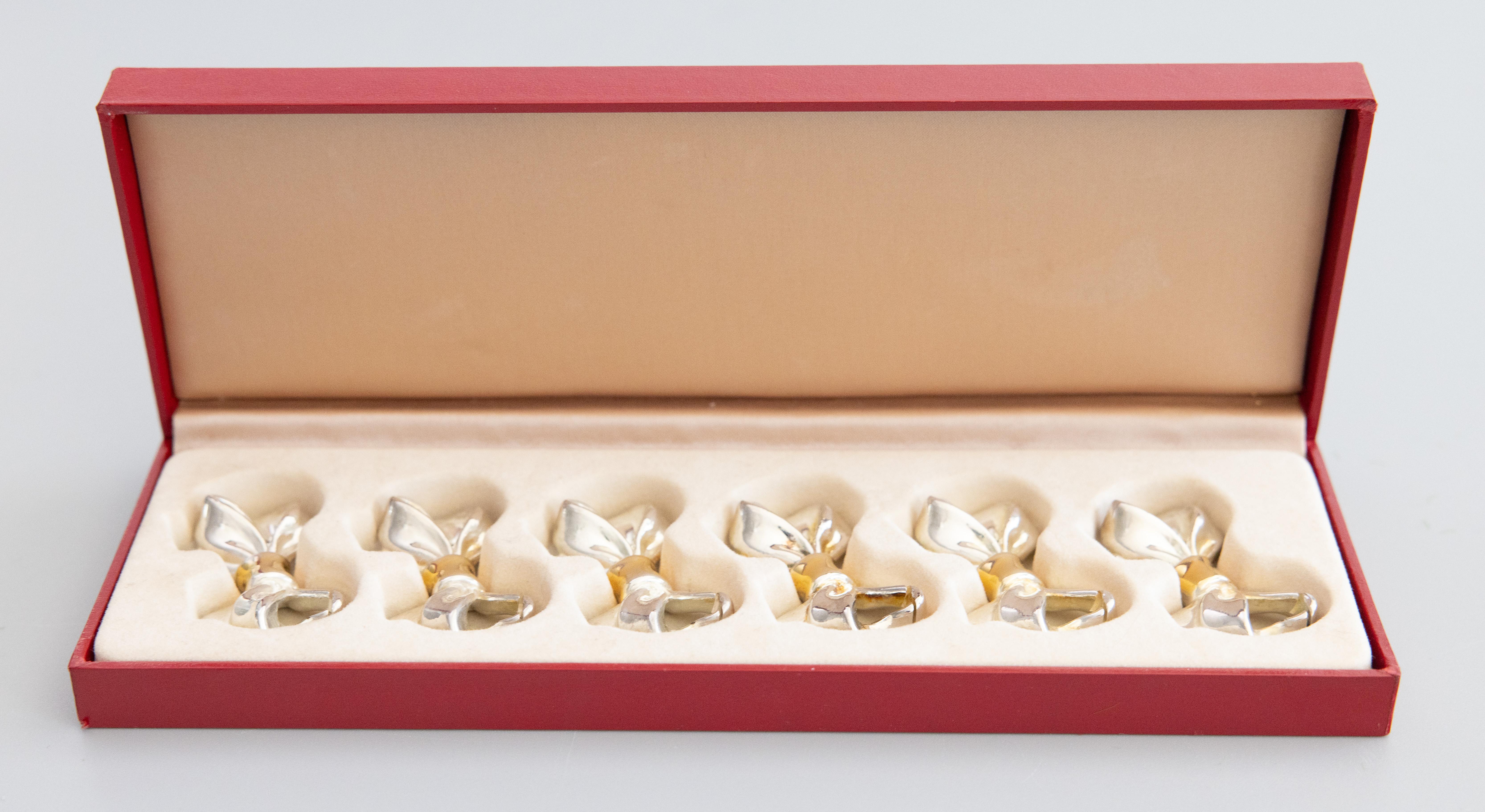 Un delizioso set vintage in scatola di sei fiocchi in metallo argentato e dorato per segnaposto, proveniente da Parigi, Francia. Nessun marchio di fabbrica. Sarebbe perfetto come decorazione da tavolo, per intrattenimenti o come regalo.

Dimensioni